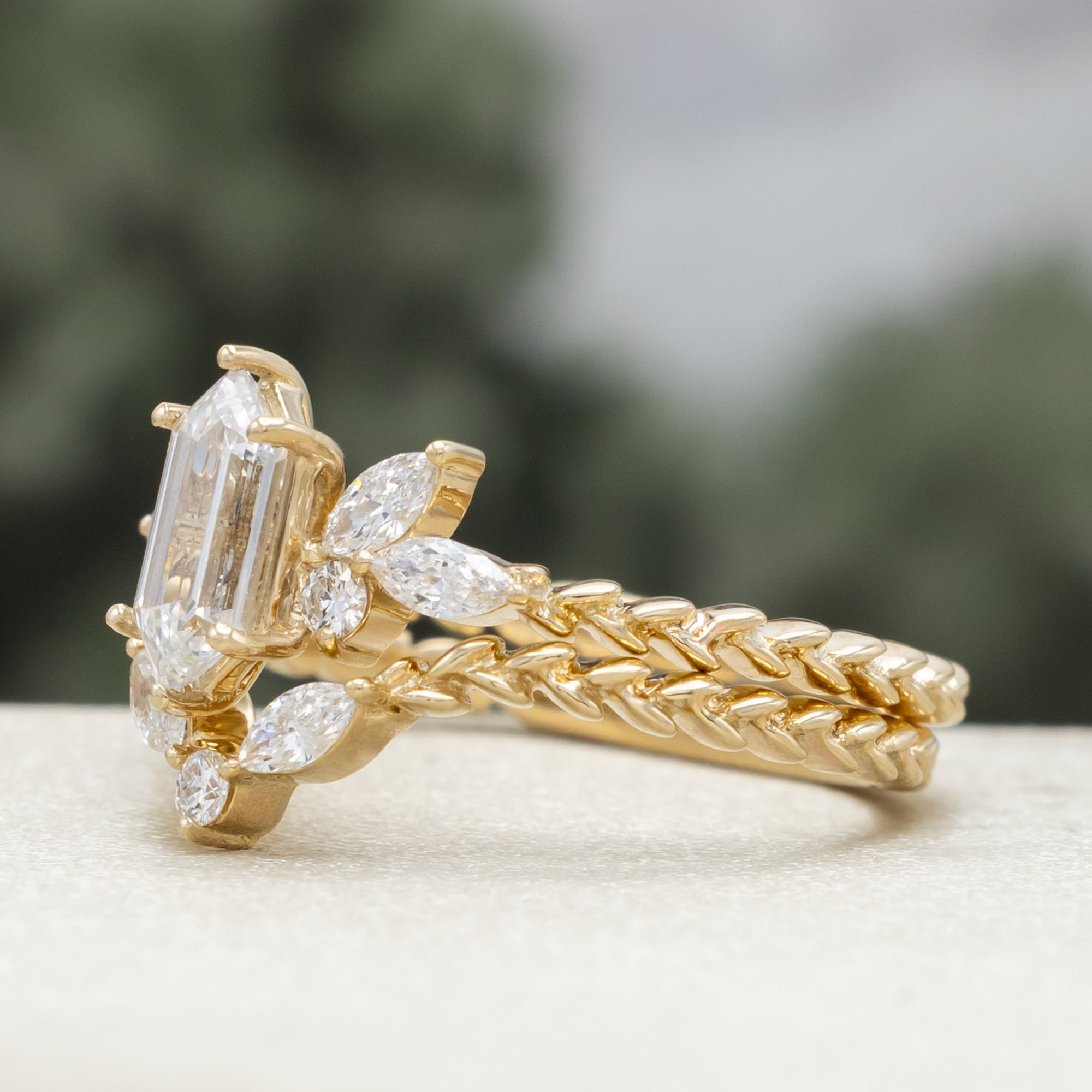 Gold ring with diamond centerstone and  accents on a neutral background
