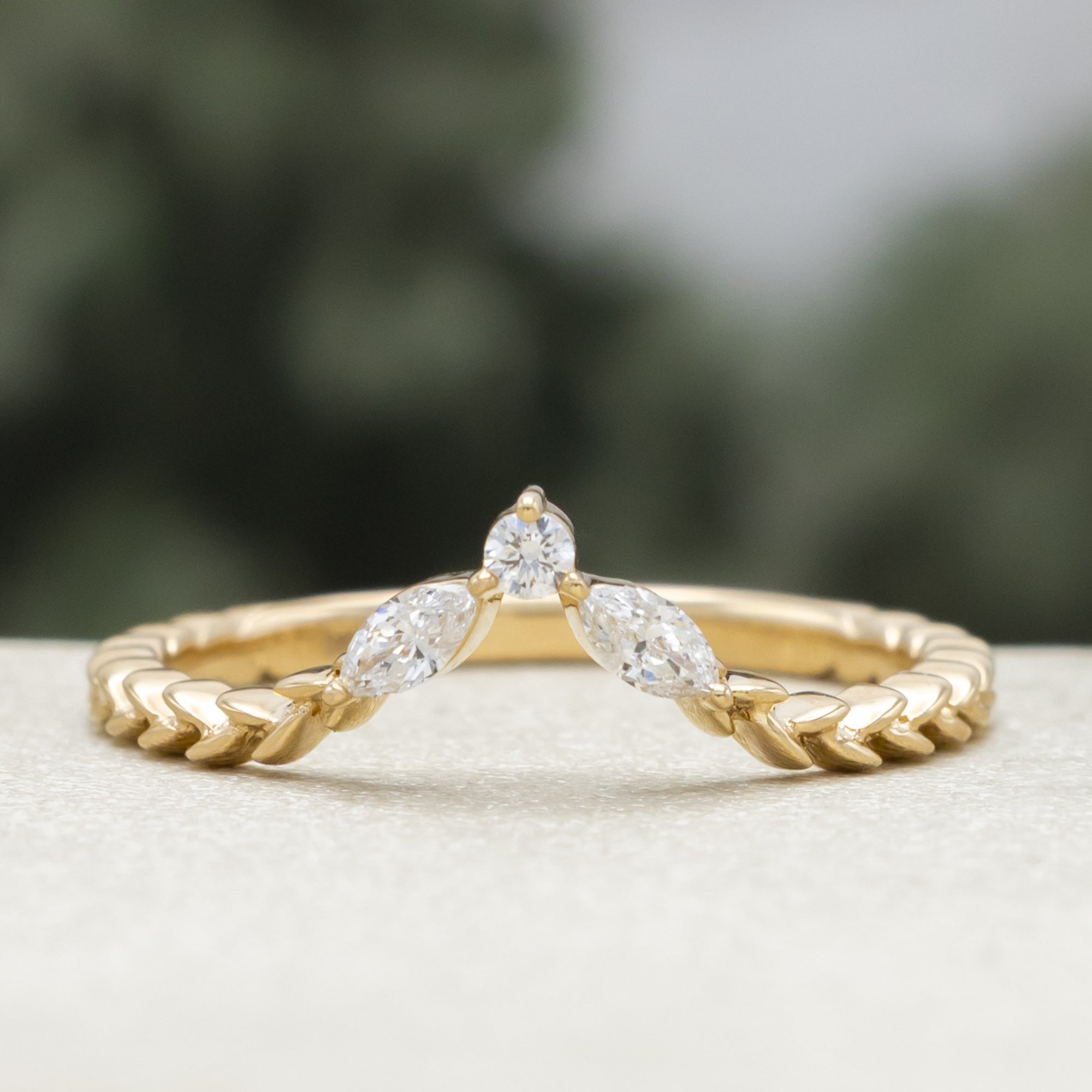 Gold ring with diamond accents on a neutral background