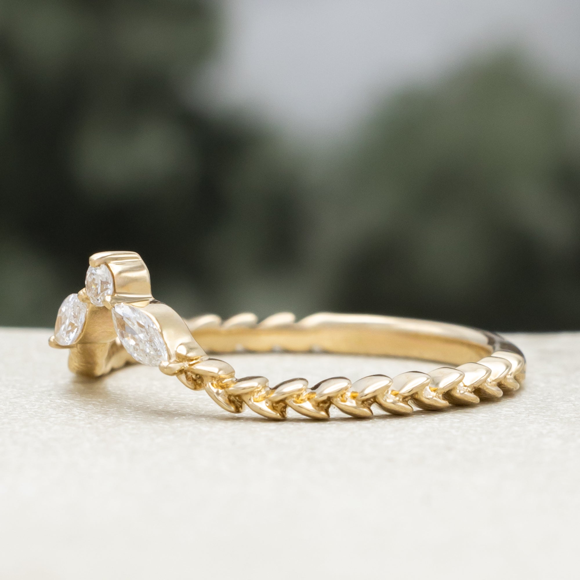 Gold ring with diamond accents on a neutral background