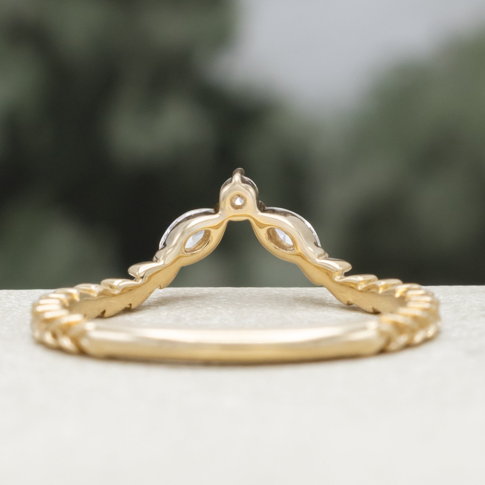 Gold ring with diamond accents on a neutral background