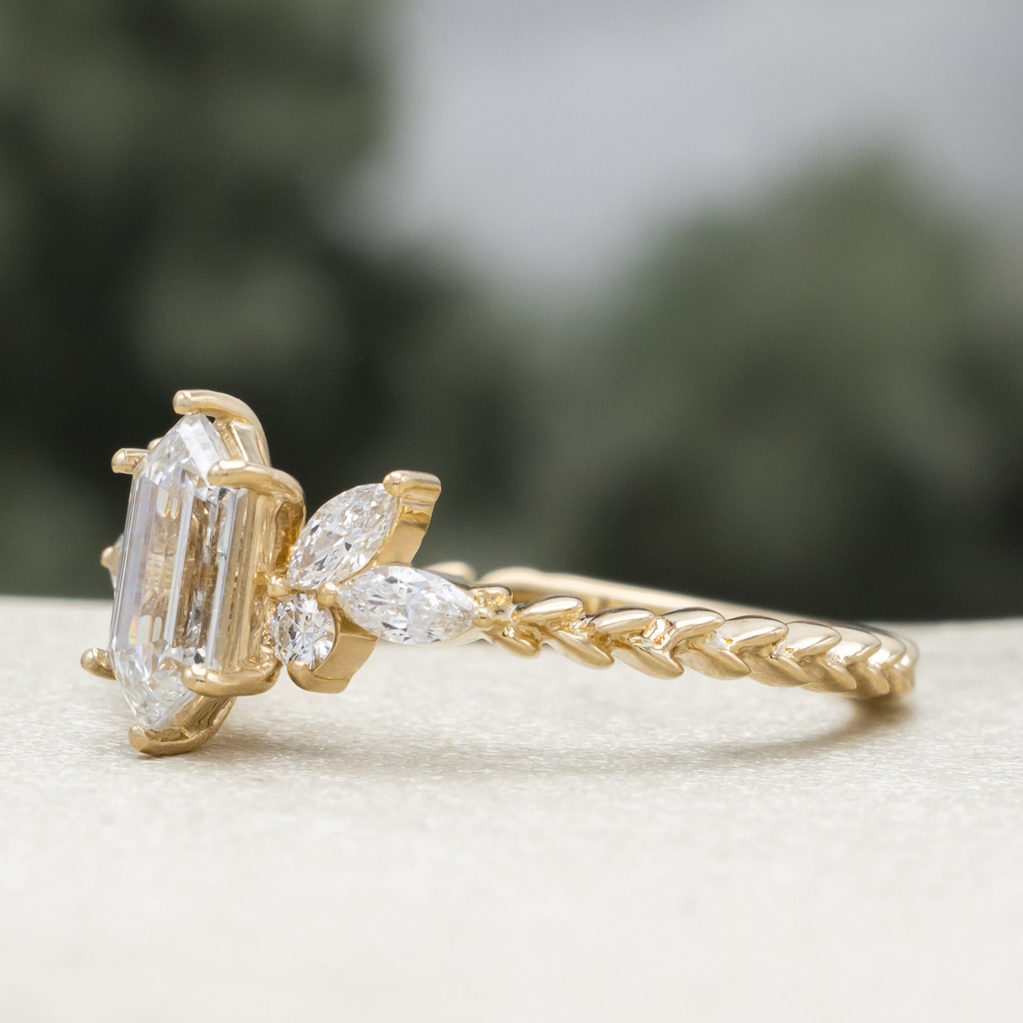 Gold ring with diamond centerstone and  accents on a neutral background
