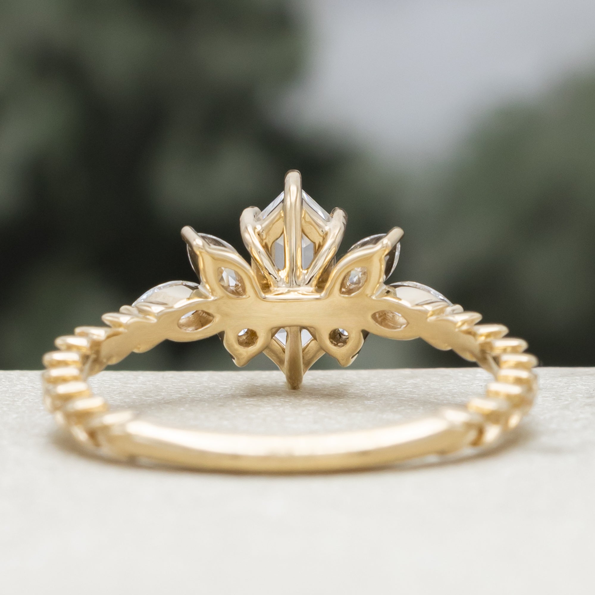 Gold ring with diamond centerstone and accents on a neutral background