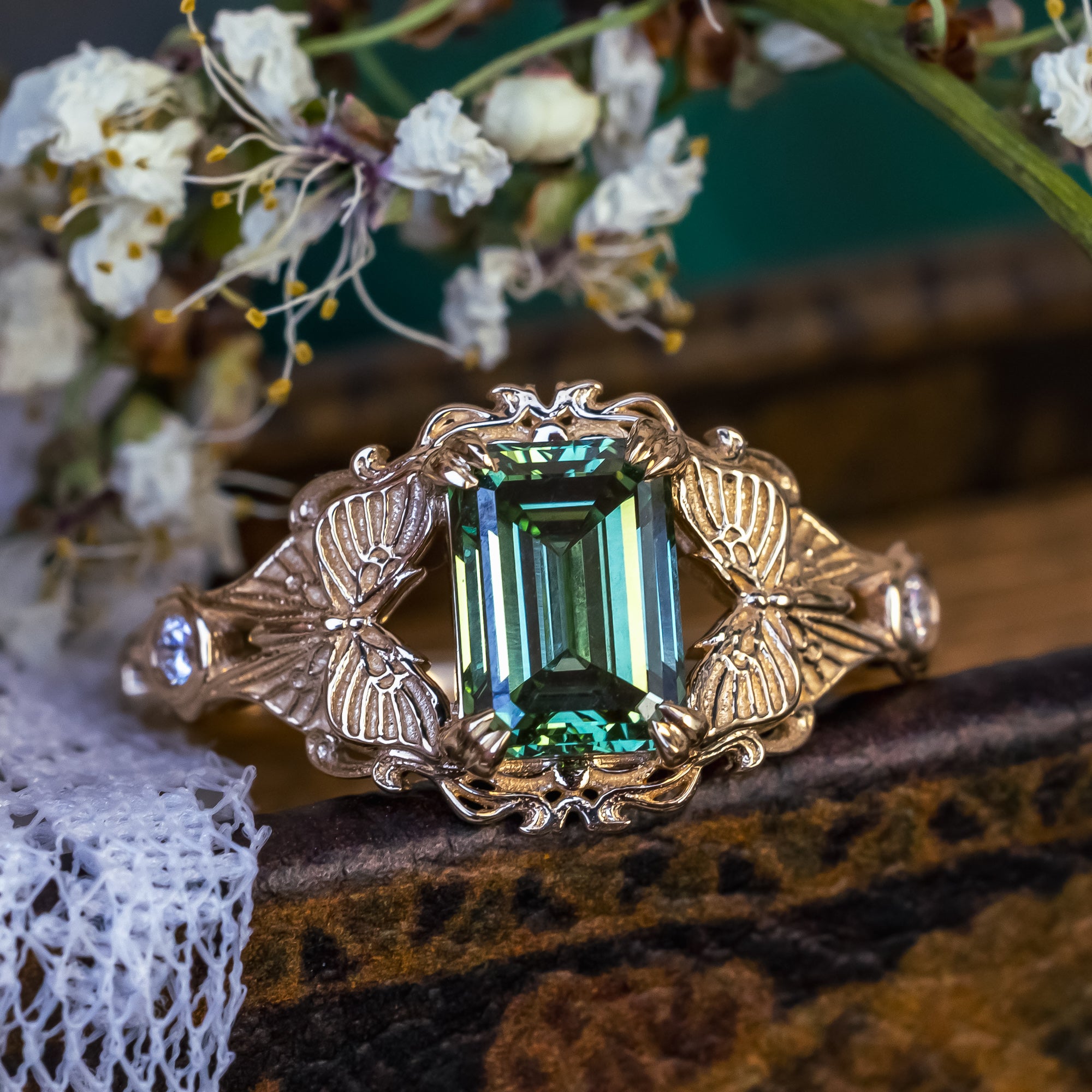 Gold ring with green lab diamond on a floral background