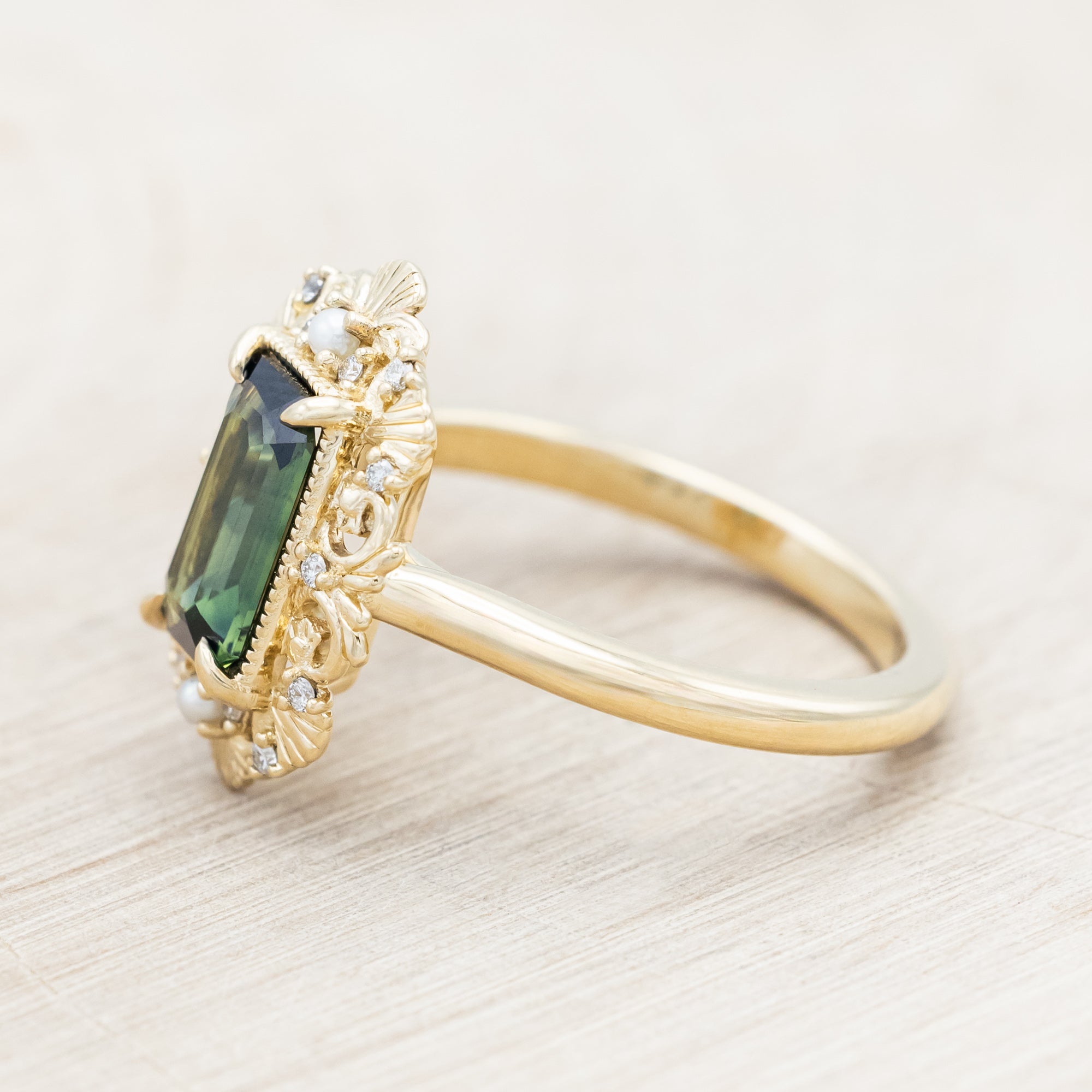 Sculptural 14K yellow gold ring with green sapphire featuring diamond and pearl accents