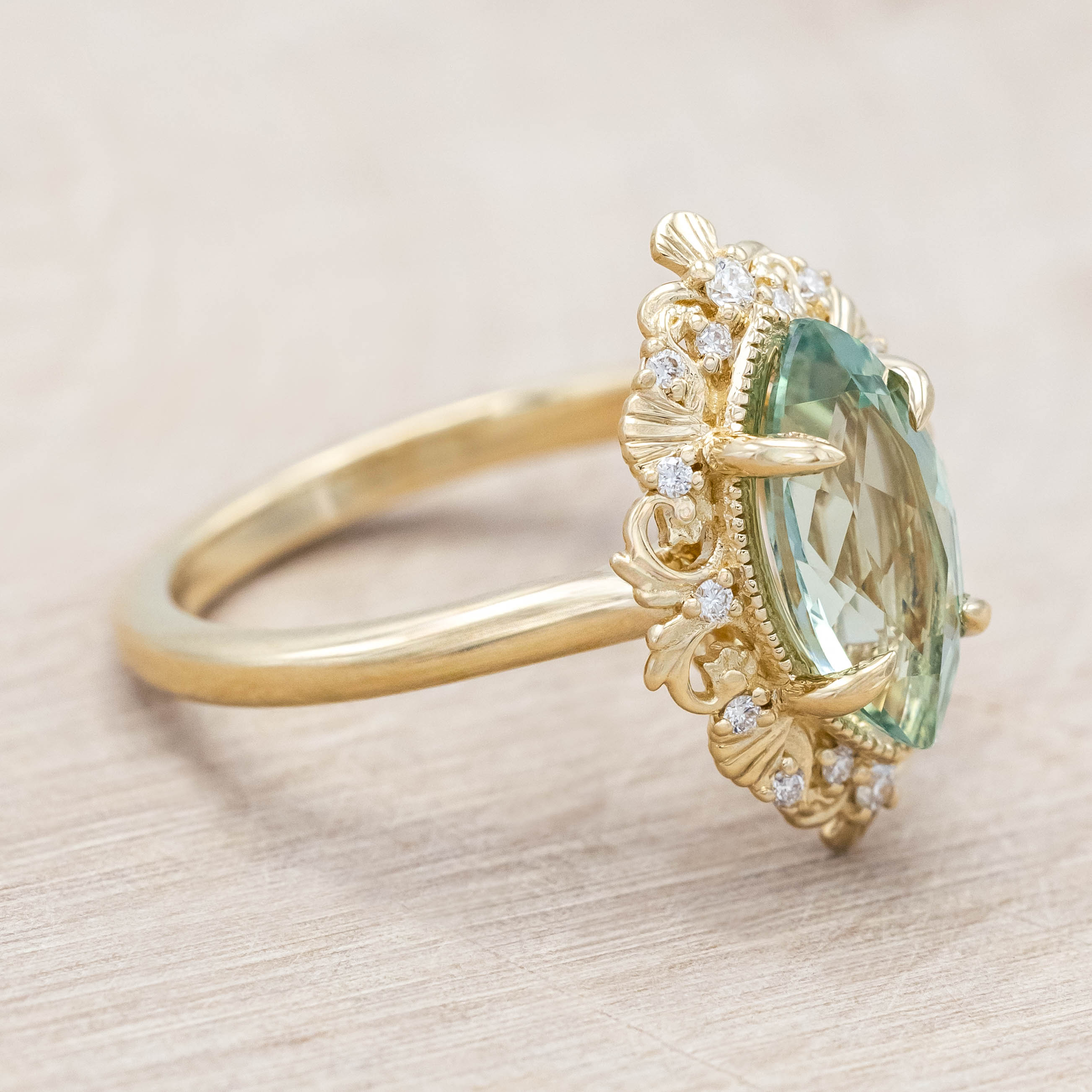 14K gold ring with a green sapphire on a light wooden background