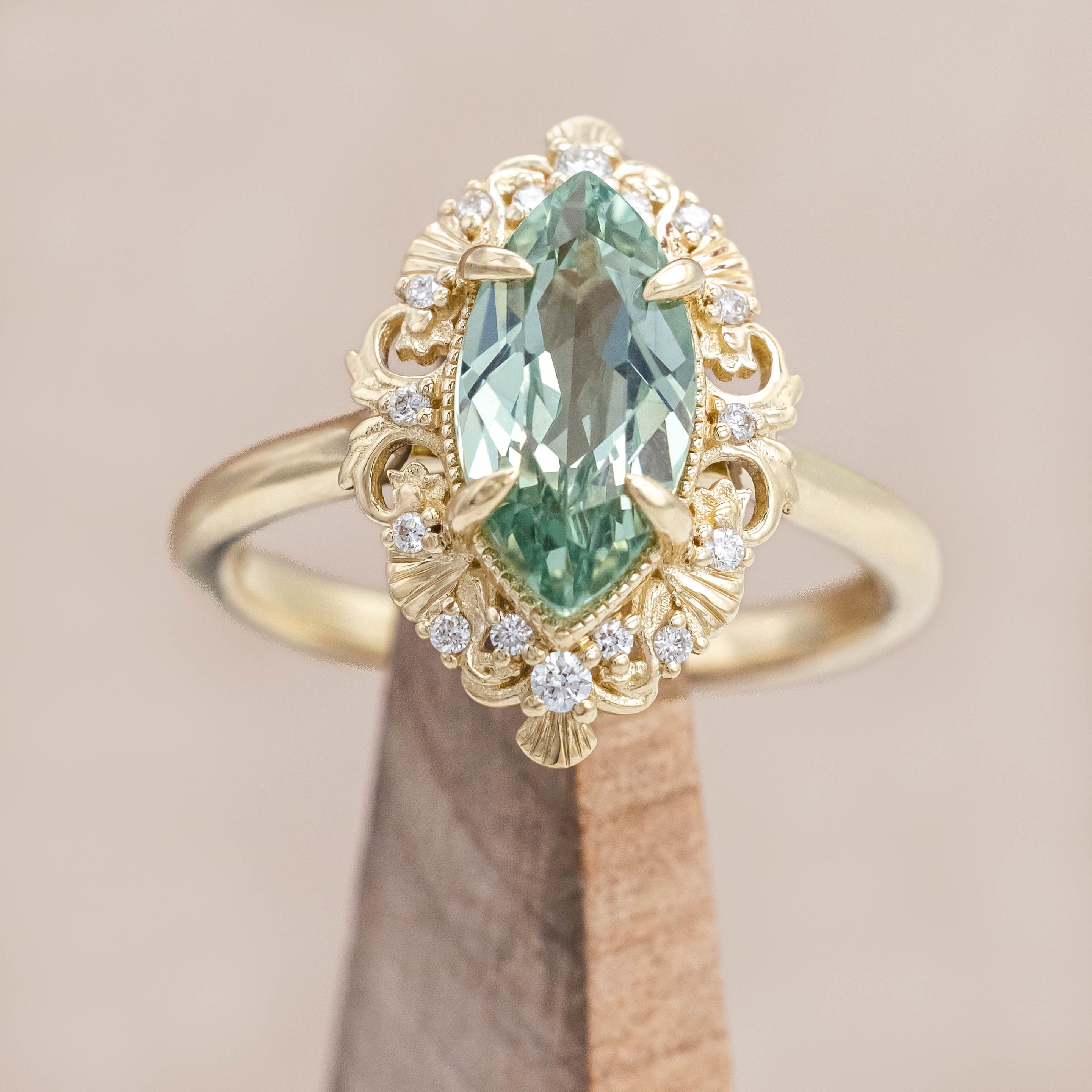 14K gold ring with a green sapphire on a beige background