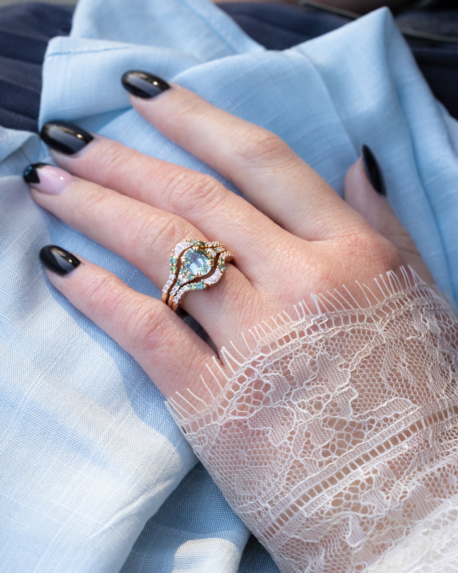 Hand wearing a decorative ring with a blue background