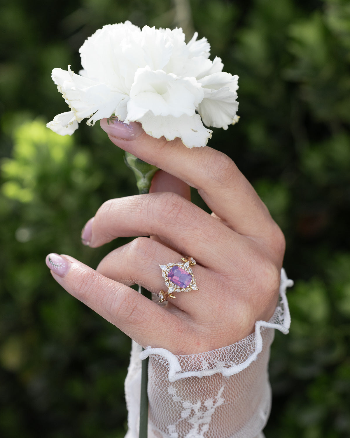 On hand photo of "Polaris" - women's engagement ring with a Sri Lanka opalescent sapphire, diamond halo & accents on a 14K yellow gold band.