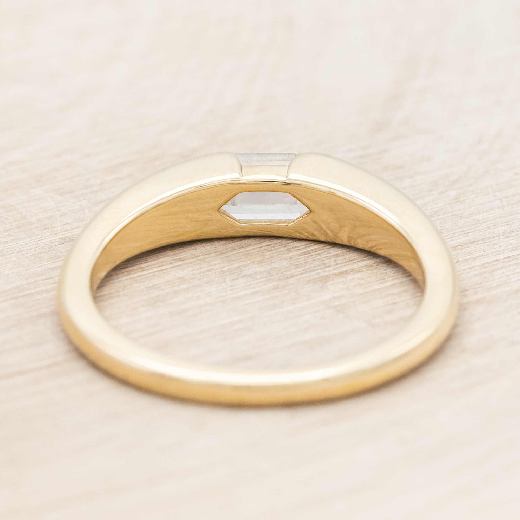 14K gold ring with a geometric stone on a wooden background
