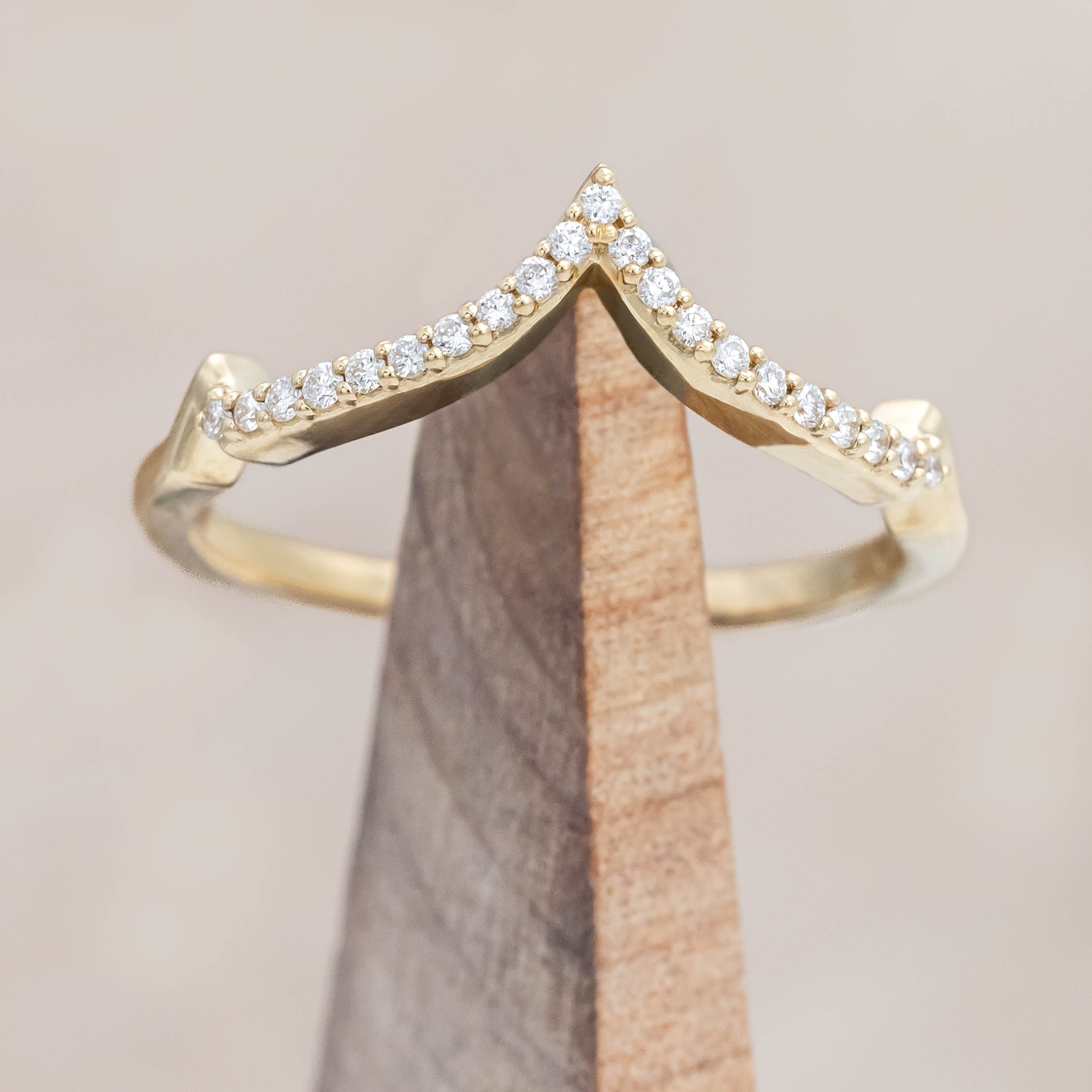 Gold ring with diamonds on a light wooden background