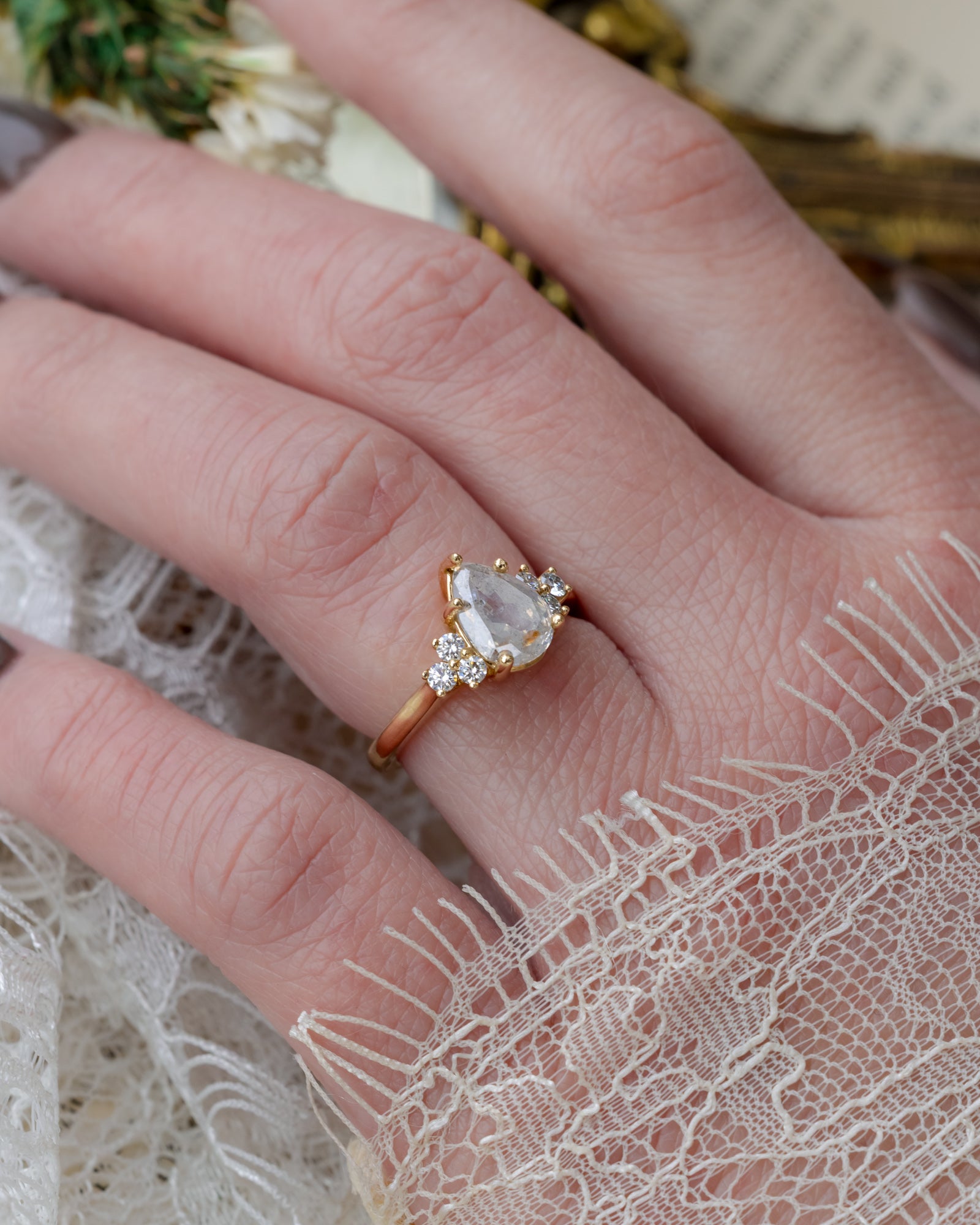 Hand wearing pear cut salt and pepper diamond ring
