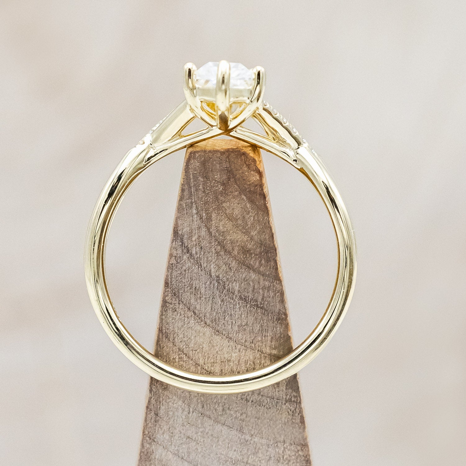 Upwards view of "Roslyn" - elongated kite cut moissanite women's engagement ring with diamond accents in 14K yellow gold