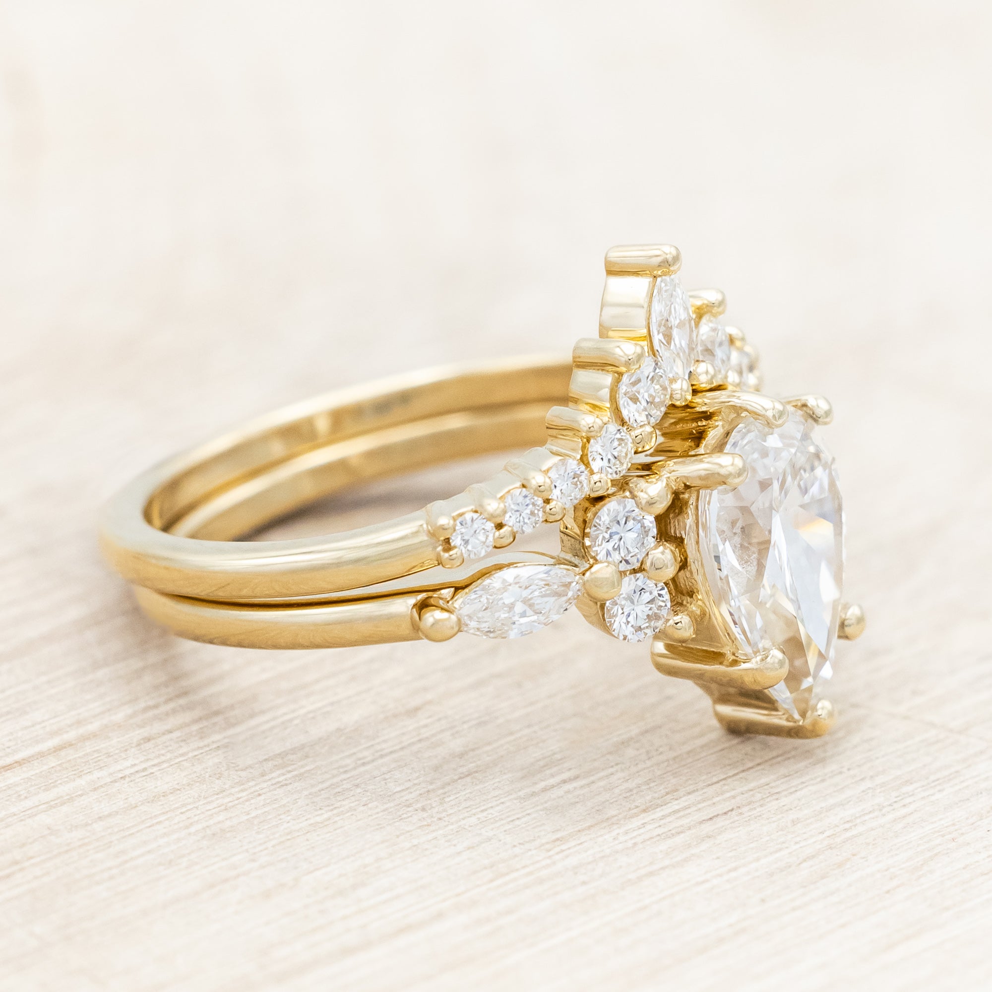 14K gold ring with a pear-cut lab diamond on a neutral background