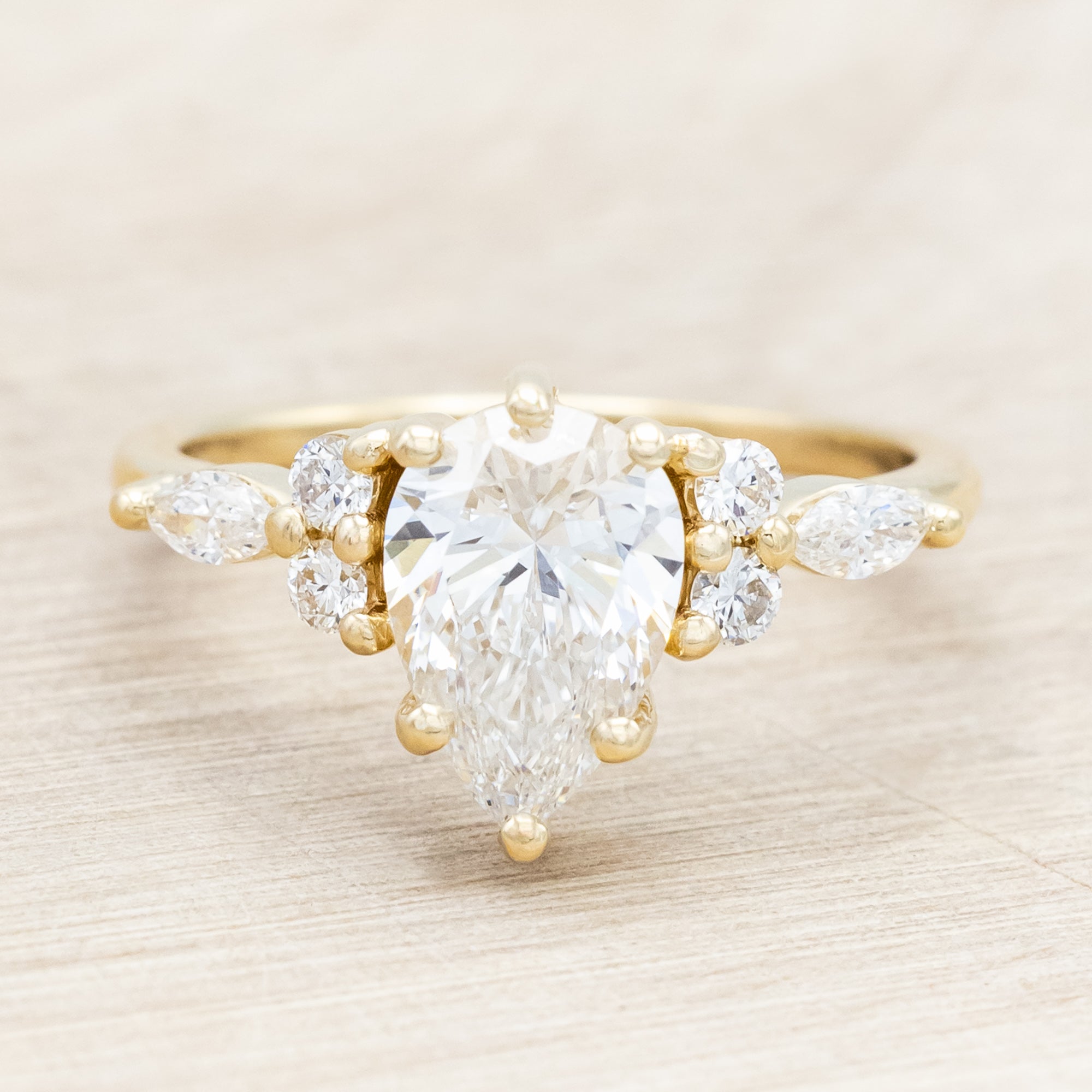 14K gold ring with a pear-cut lab diamond on a neutral background