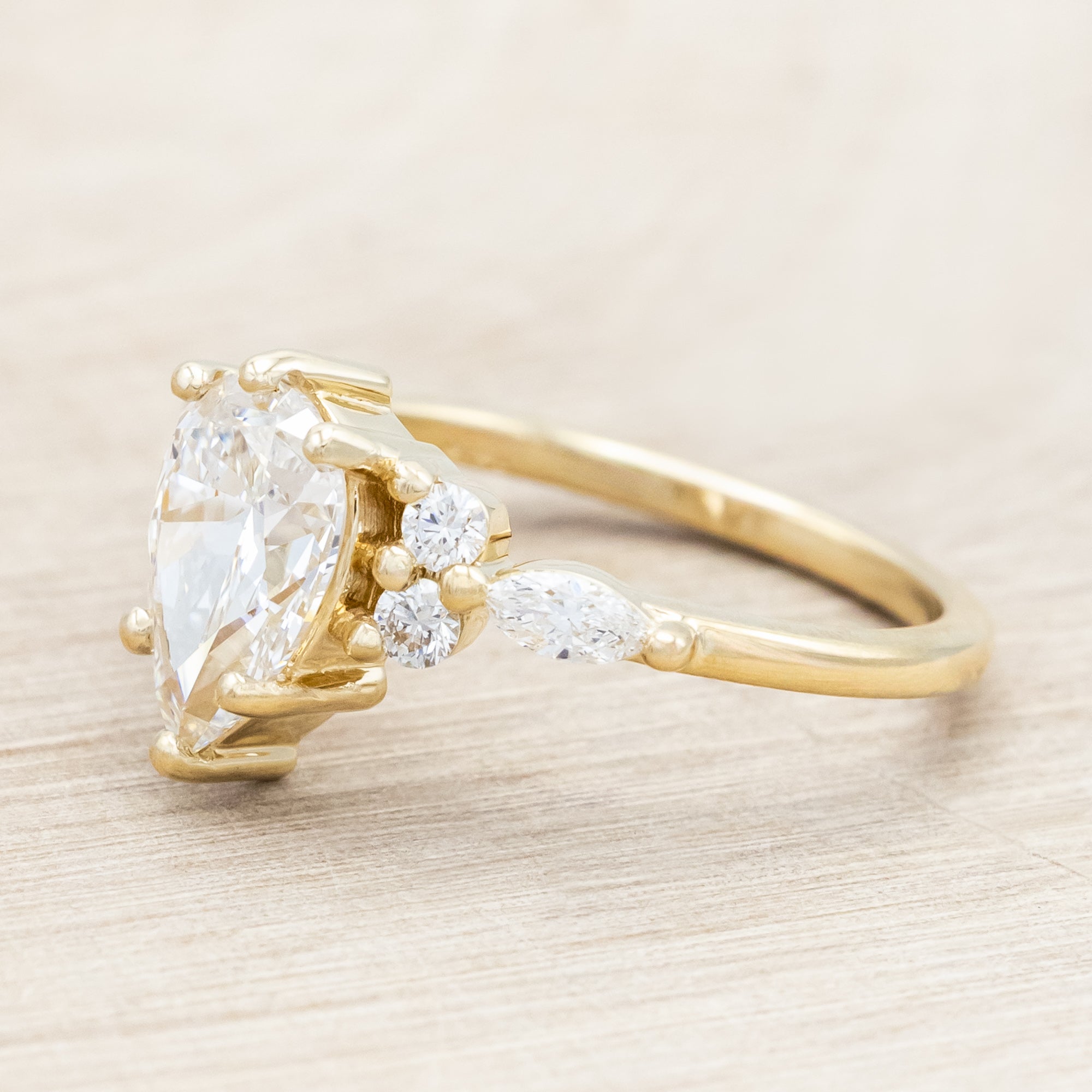 14K gold ring with a pear-cut lab diamond on a neutral background