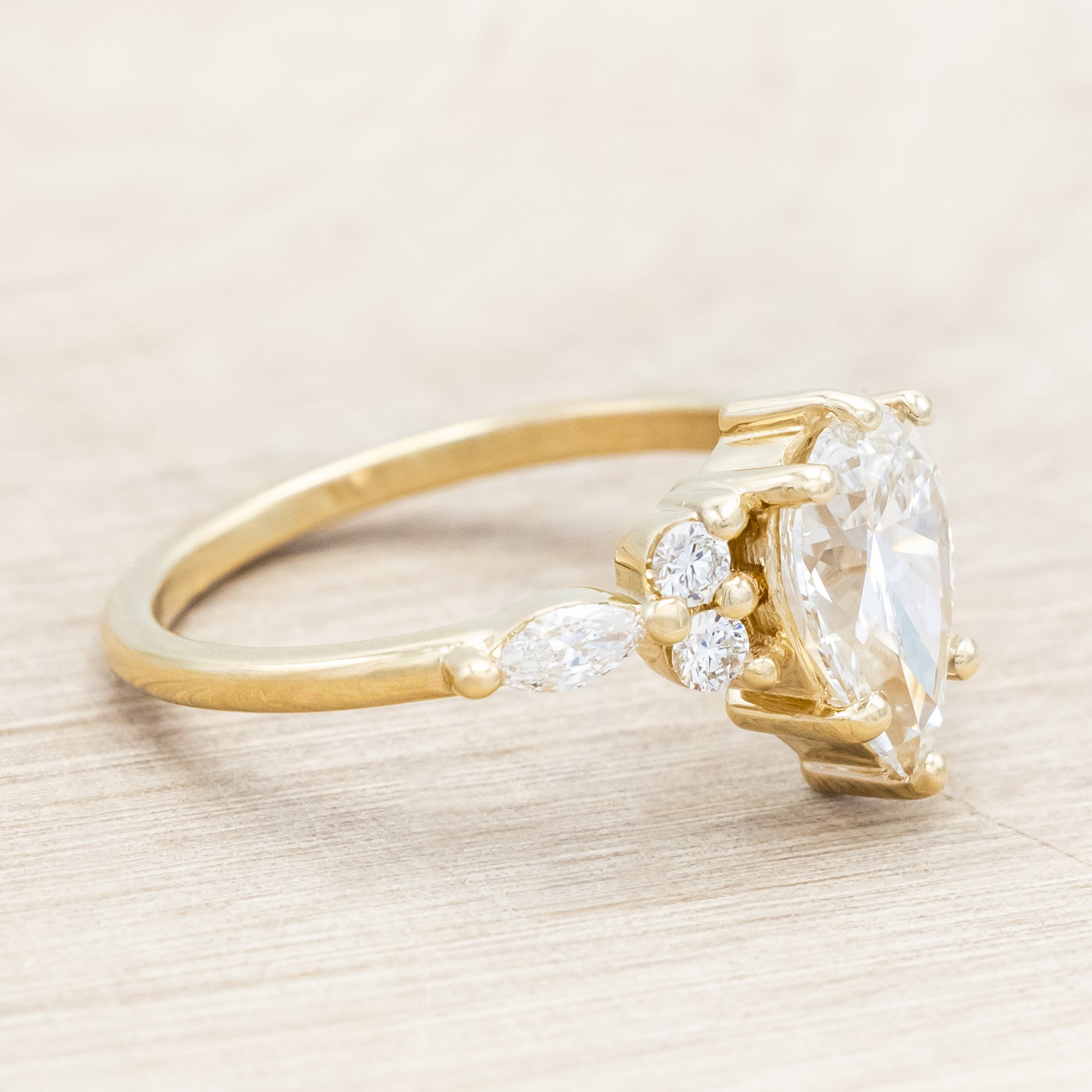 14K gold ring with a pear-cut lab diamond on a neutral background