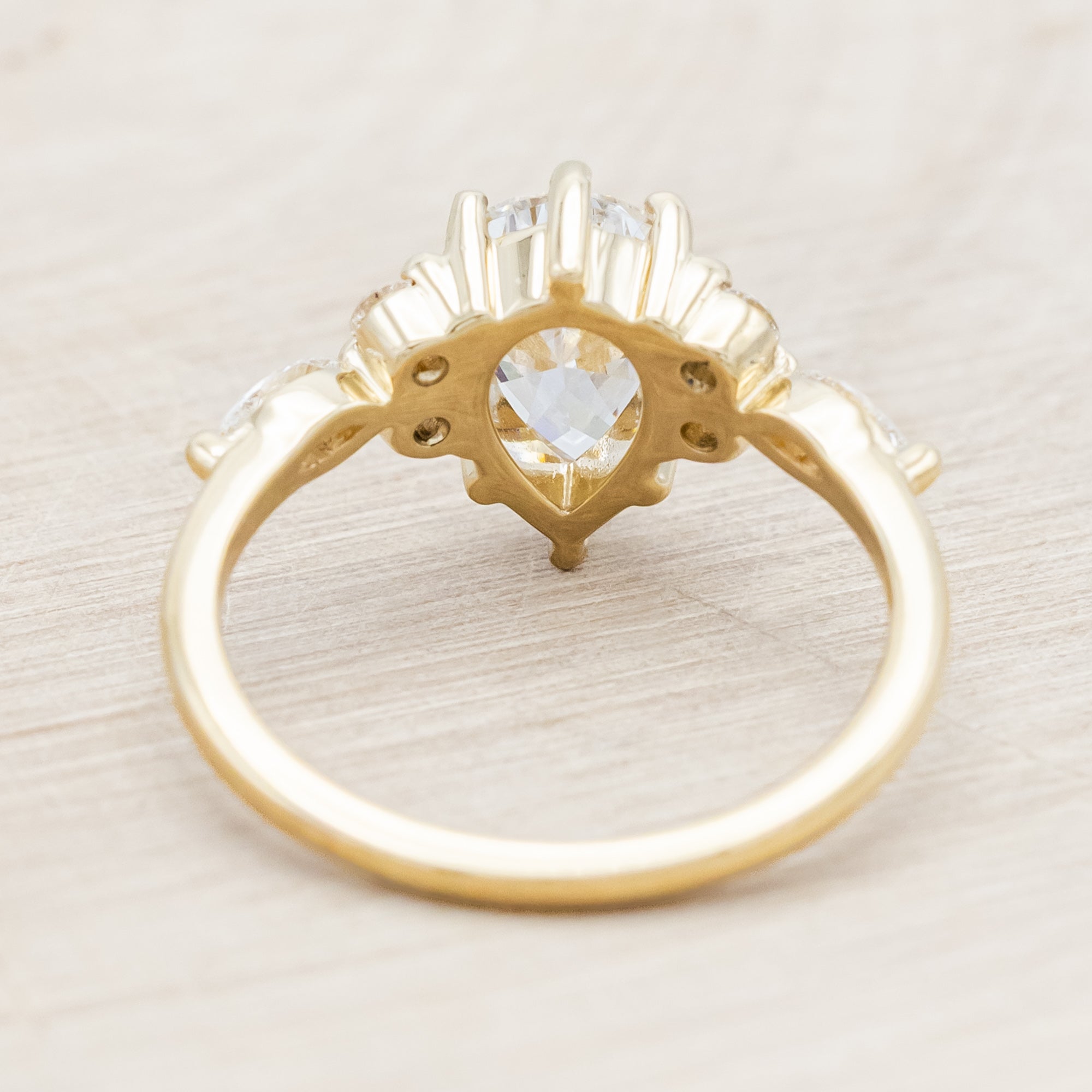 14K gold ring with a pear-cut lab diamond on a neutral background