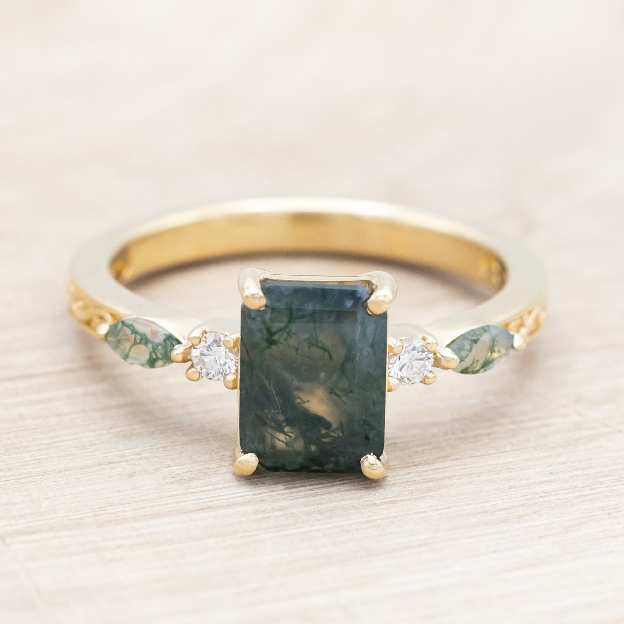 14K gold ring with a moss agate and diamonds on a beige background