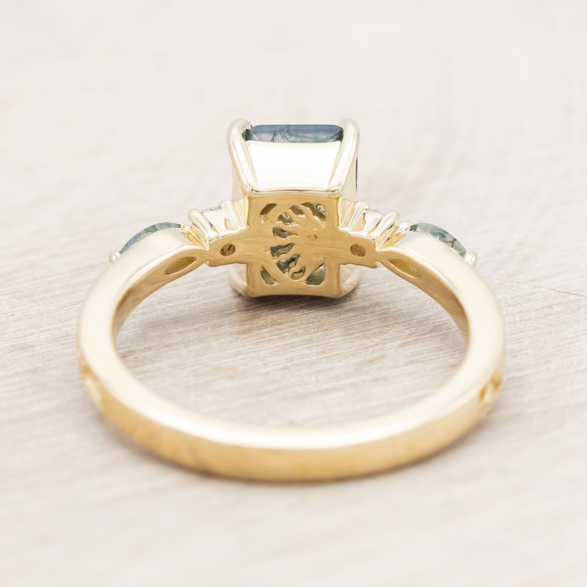 14K gold ring with a moss agate and diamonds on a beige background