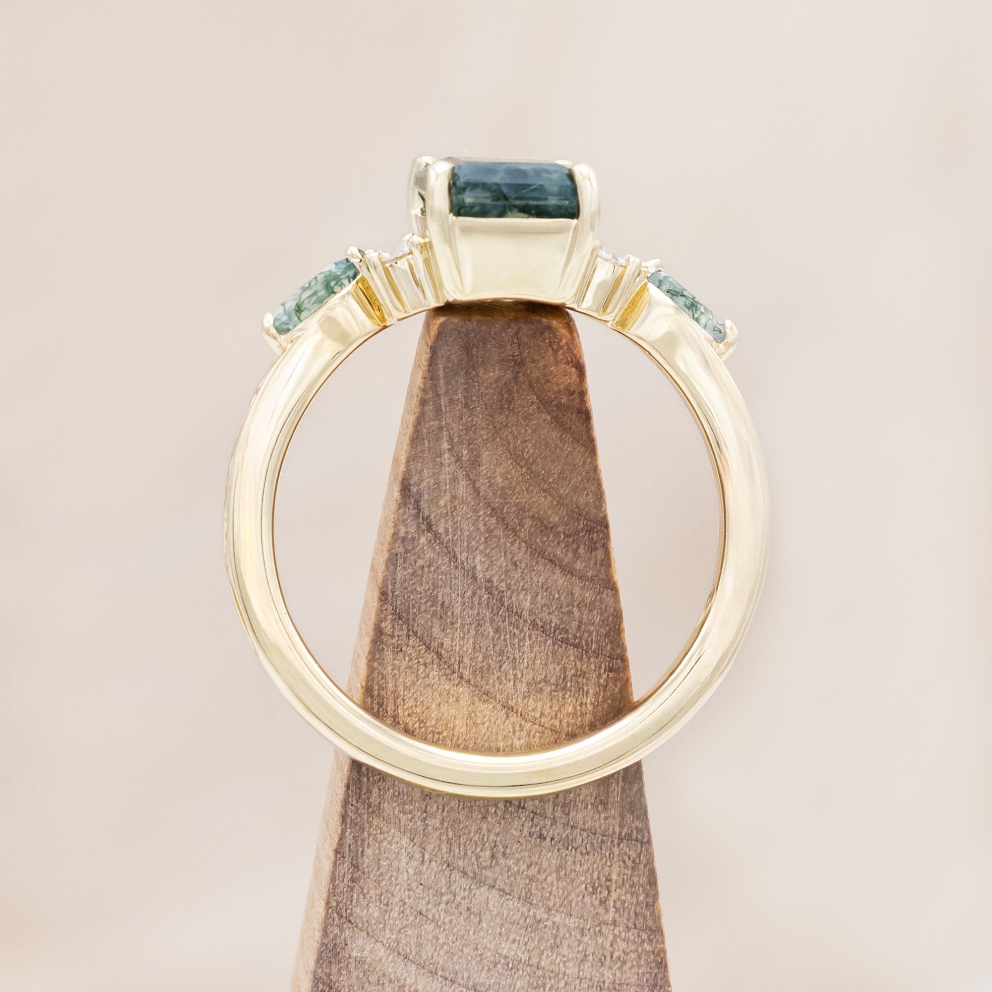 14K gold ring with a moss agate and diamonds on a beige background