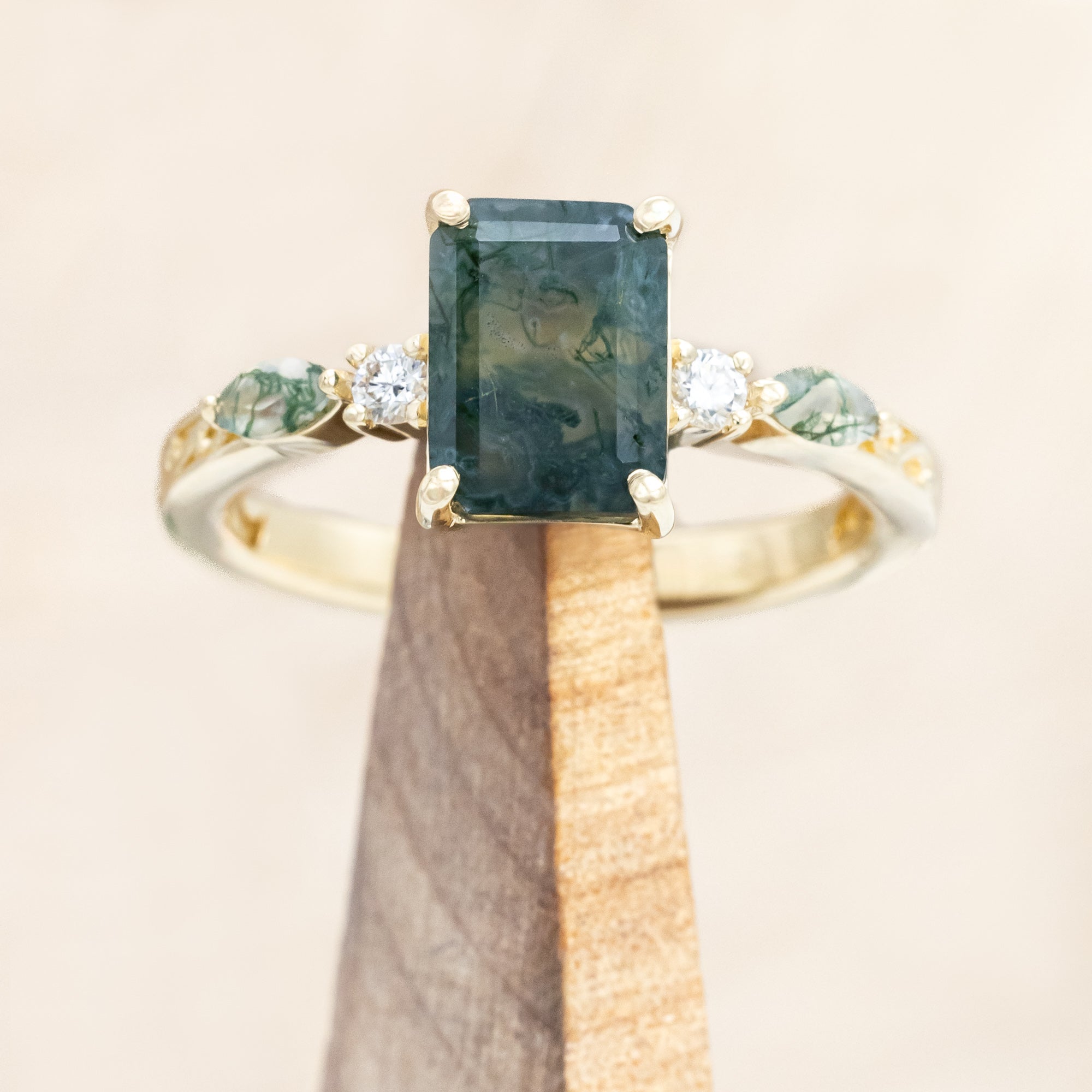14K gold ring with a moss agate and diamonds on a beige background
