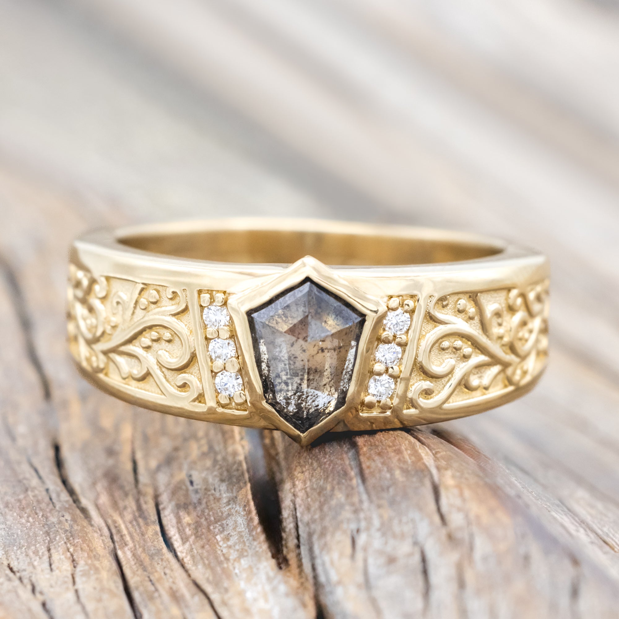 14K yellow gold ring with salt & pepper diamond and diamond accents on a wooden surface