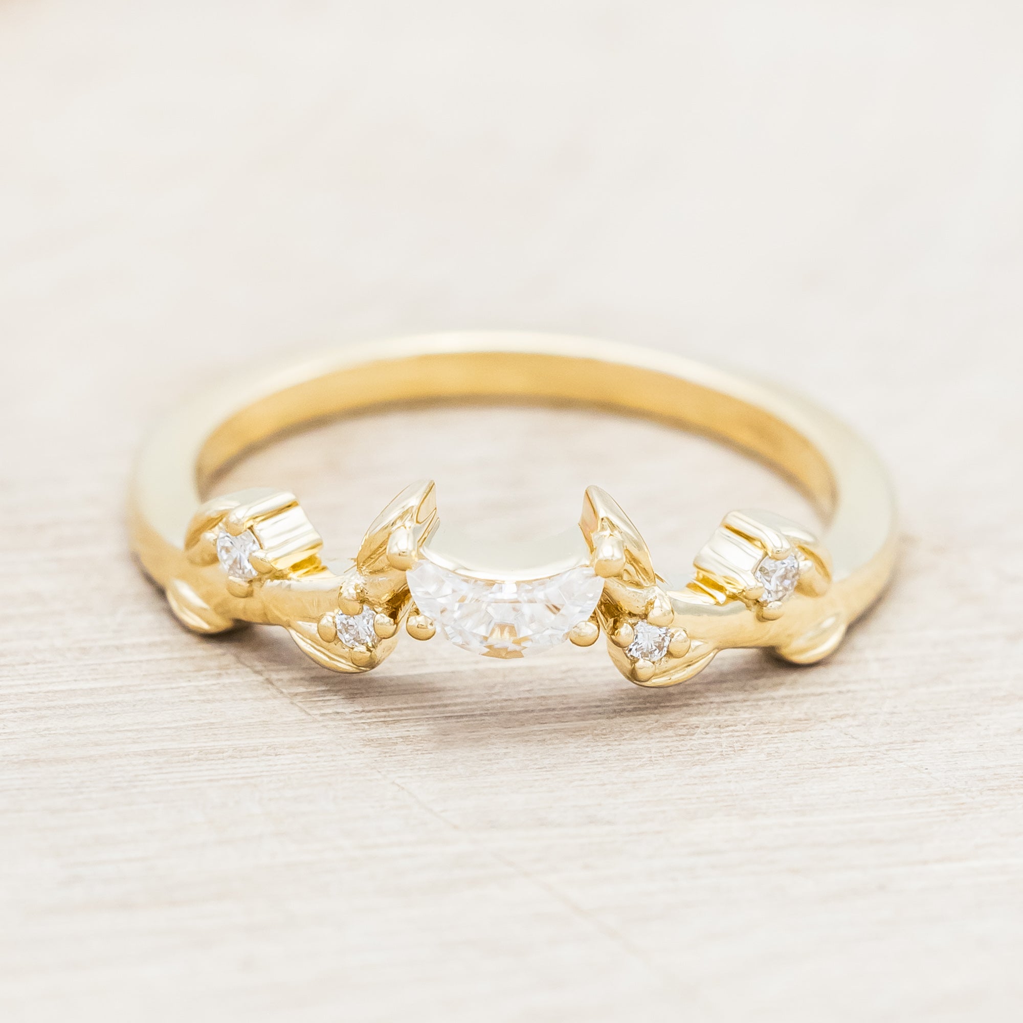 14K gold ring with diamond & moissanite accents on a beige background