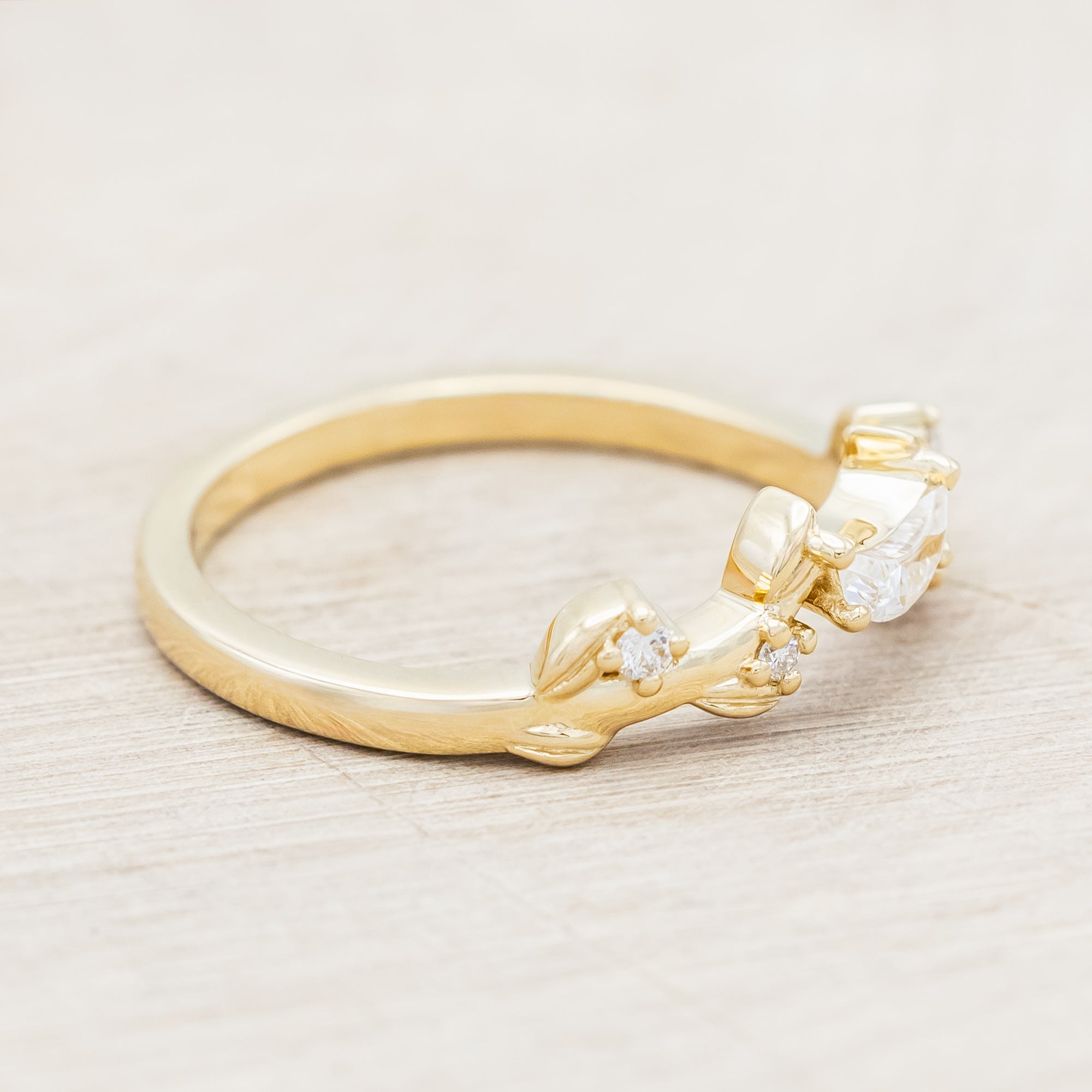 14K gold ring with diamond & moissanite accents on a beige background