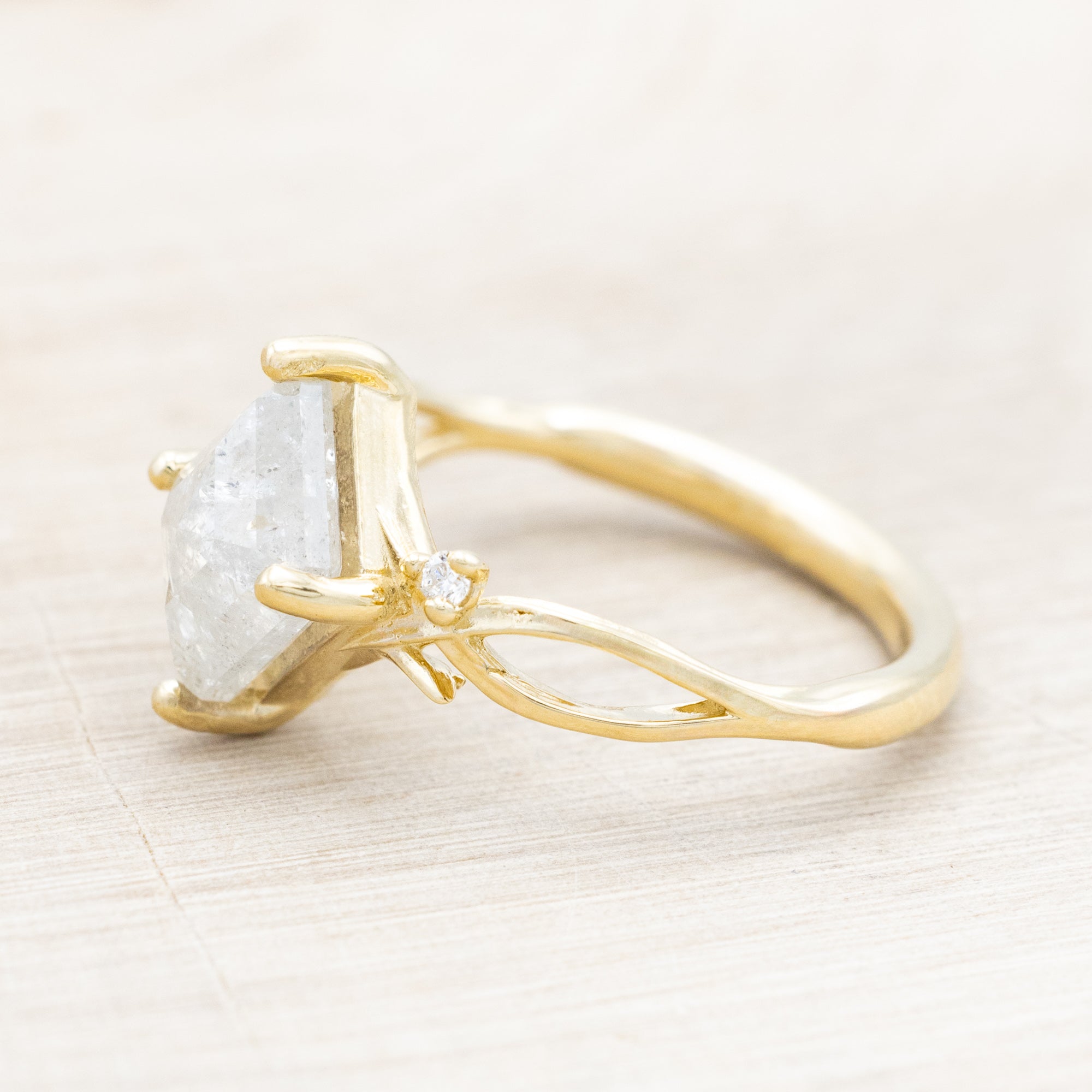 14K yellow gold ring with a salt & pepper diamond and diamond accents on a beige background