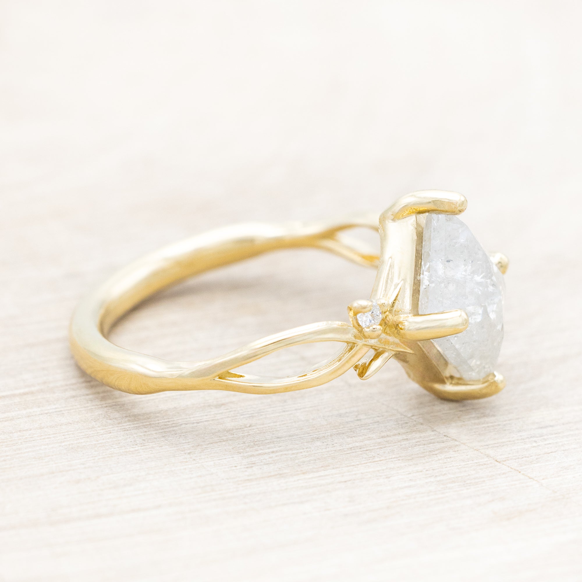 14K yellow gold ring with a salt & pepper diamond and diamond accents on a beige background