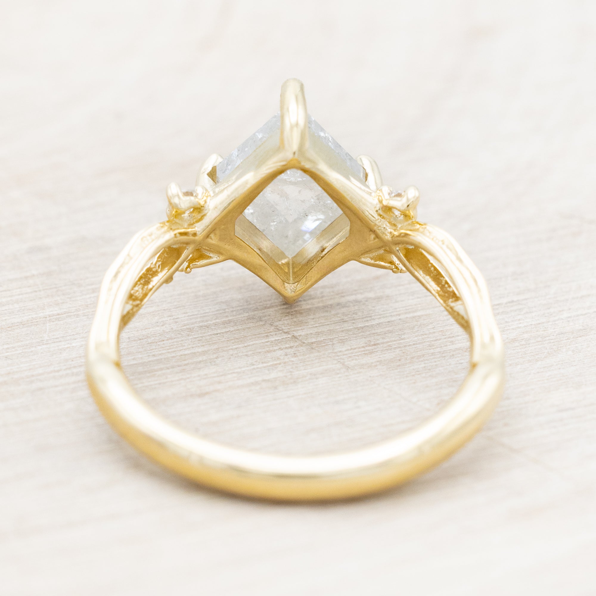 14K yellow gold ring with a salt & pepper diamond and diamond accents on a beige background