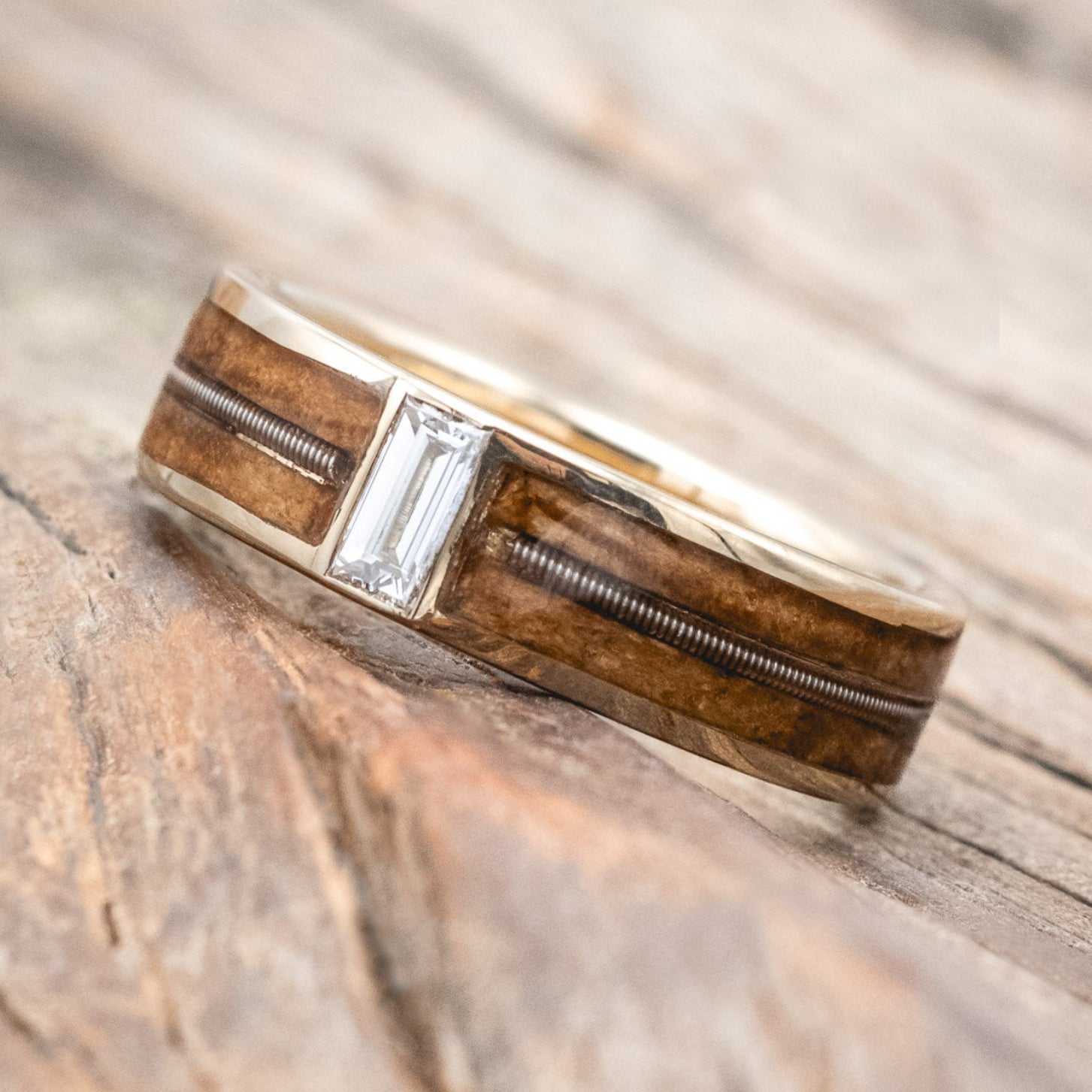 "Vaughan" Men's Wedding Ring with whiskey barrel oak inlays divided by a guitar string & lab-grown baguette cut diamond. 