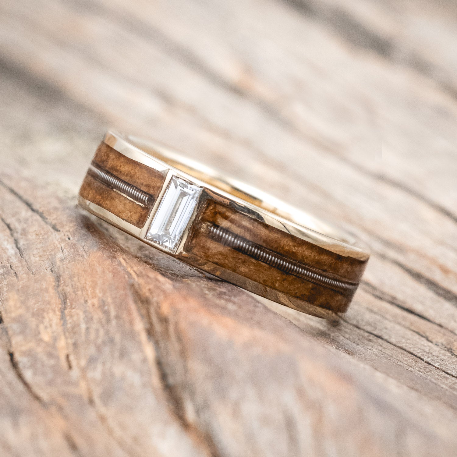 "Vaughan" Men's Wedding Ring with whiskey barrel oak inlays divided by a guitar string & lab-grown baguette cut diamond. 