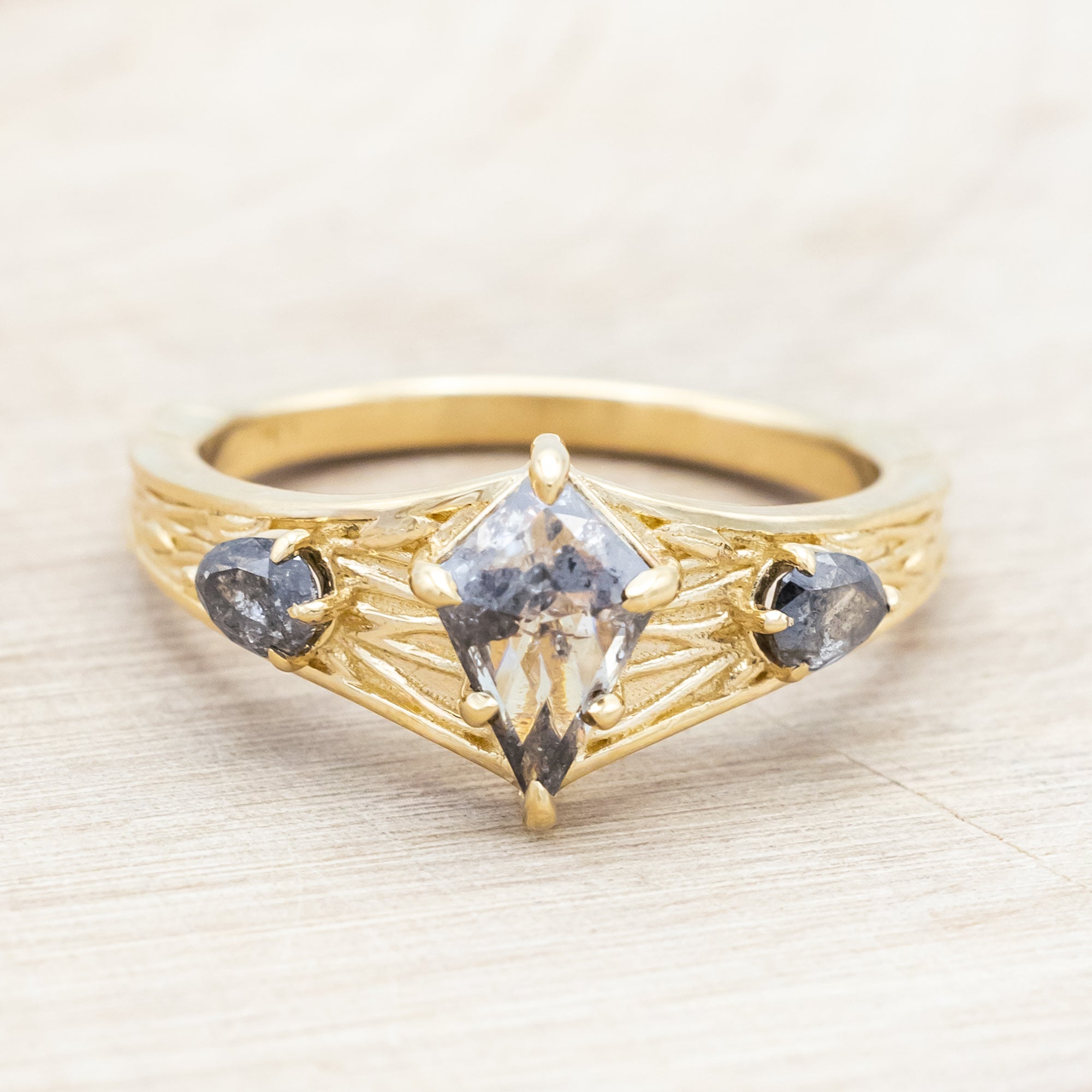 14K gold ring with salt & pepper diamond on a wooden surface