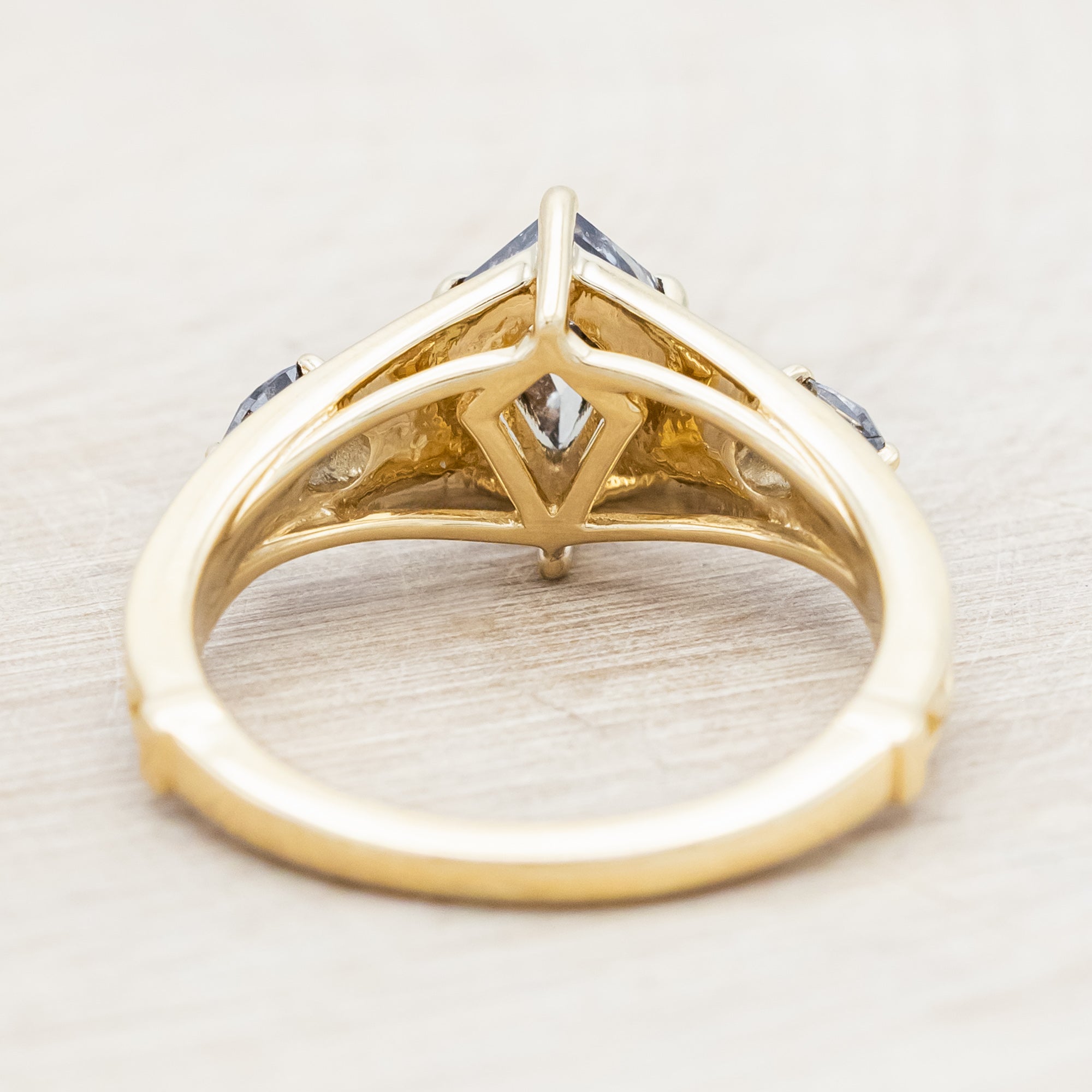 14K gold ring with salt & pepper diamond on a wooden surface