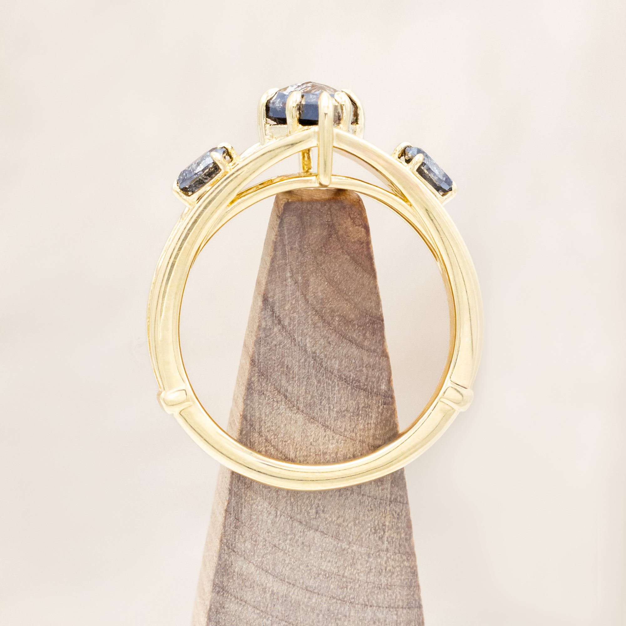 14K gold ring with salt & pepper diamond on a wooden surface
