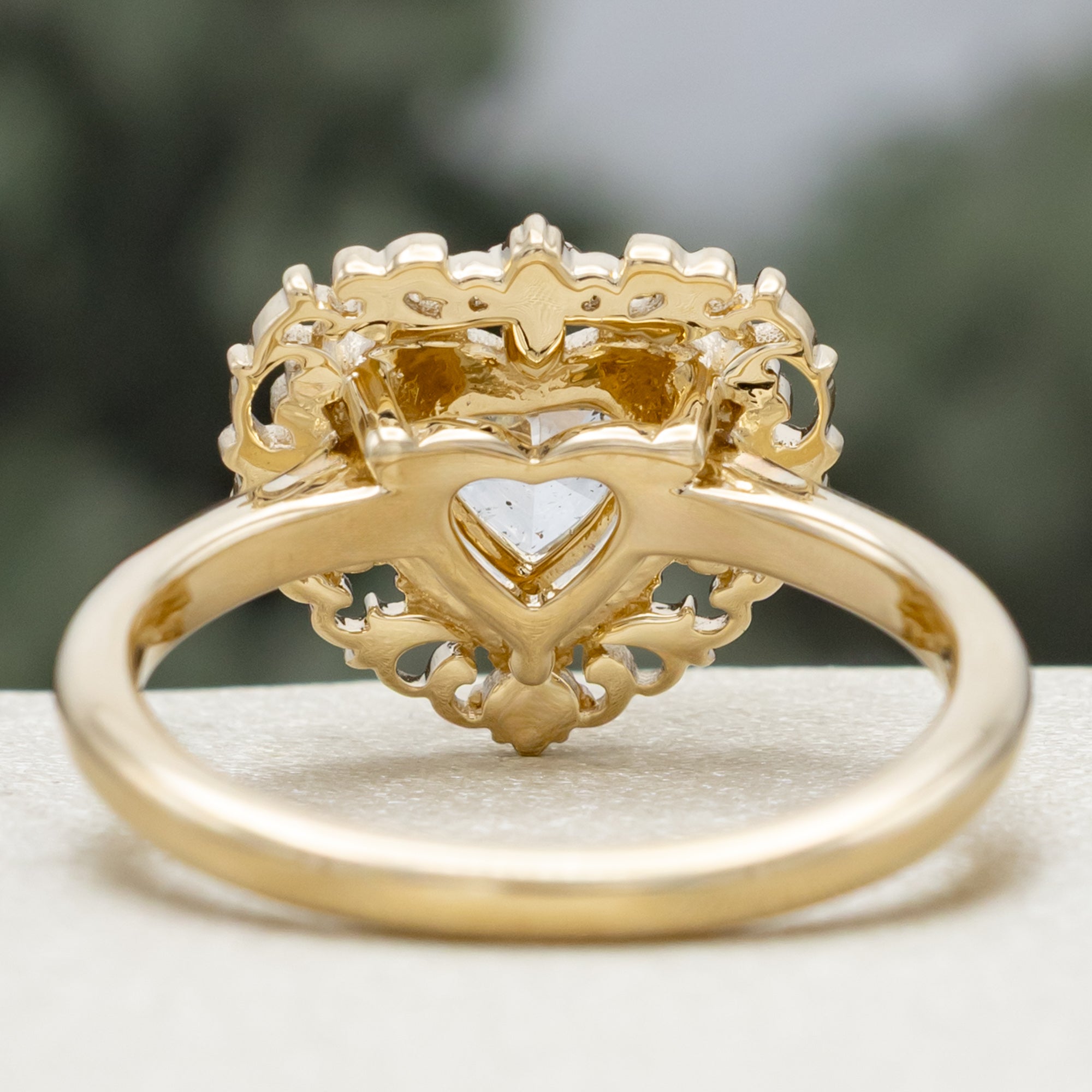 Gold ring with a heart-shaped salt & pepper diamond on a blurred background