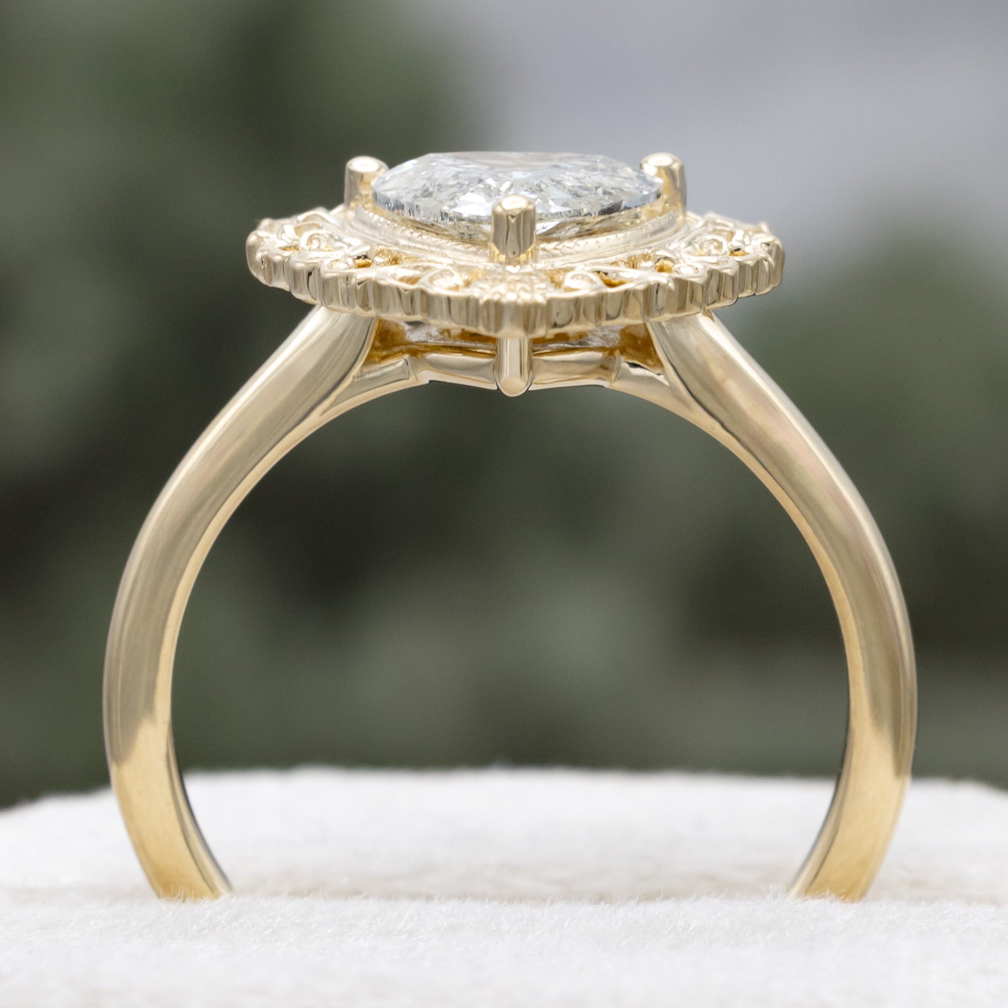 Gold ring with a heart-shaped salt & pepper diamond on a blurred background