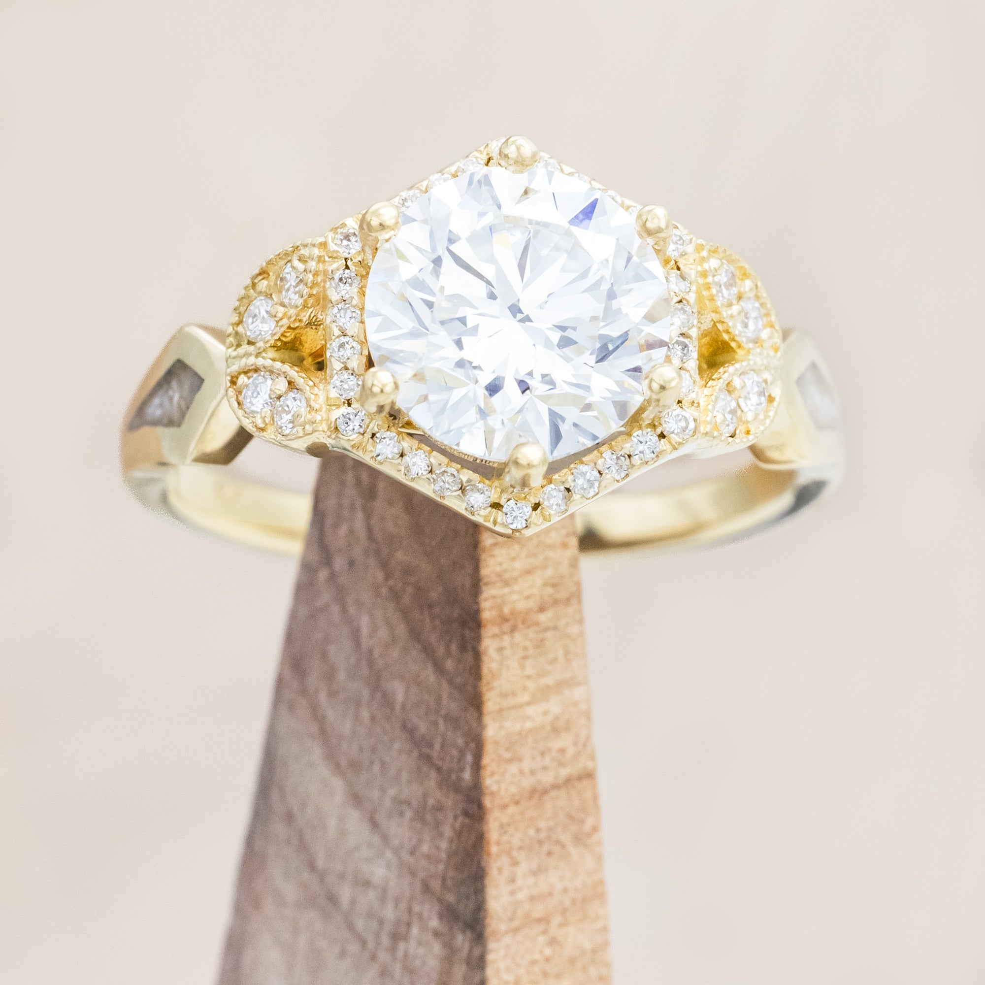 Yellow gold ring with a lab-grown diamond and diamond accents on a beige background
