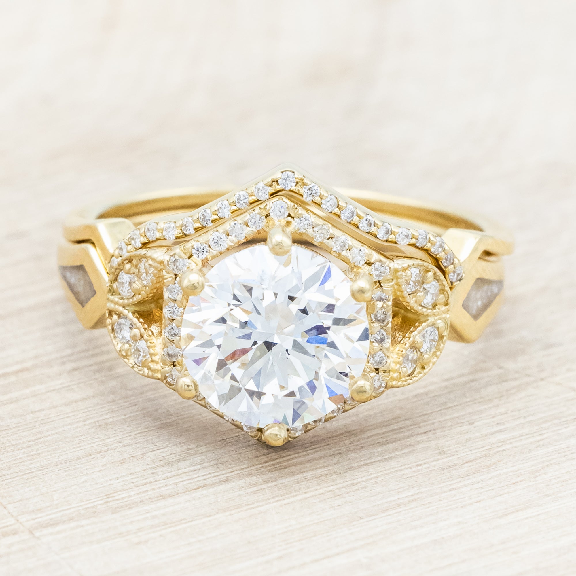 Yellow gold ring with a lab-grown diamond and diamond accents with diamond tracer on a beige background