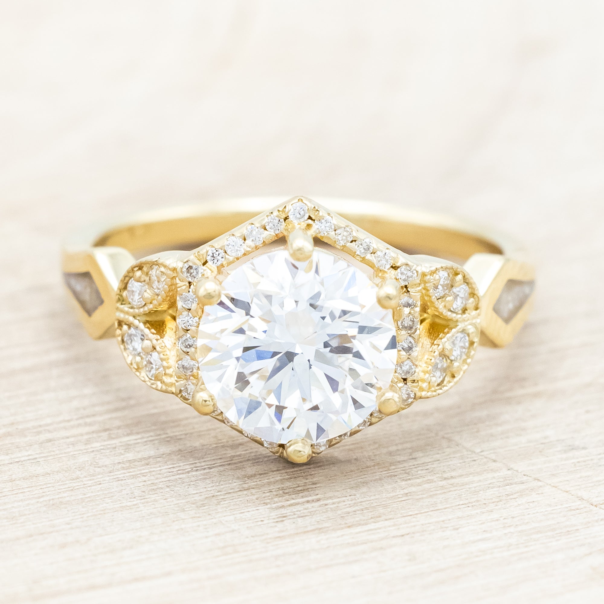 Yellow gold ring with a lab-grown diamond and diamond accentsr on a beige background