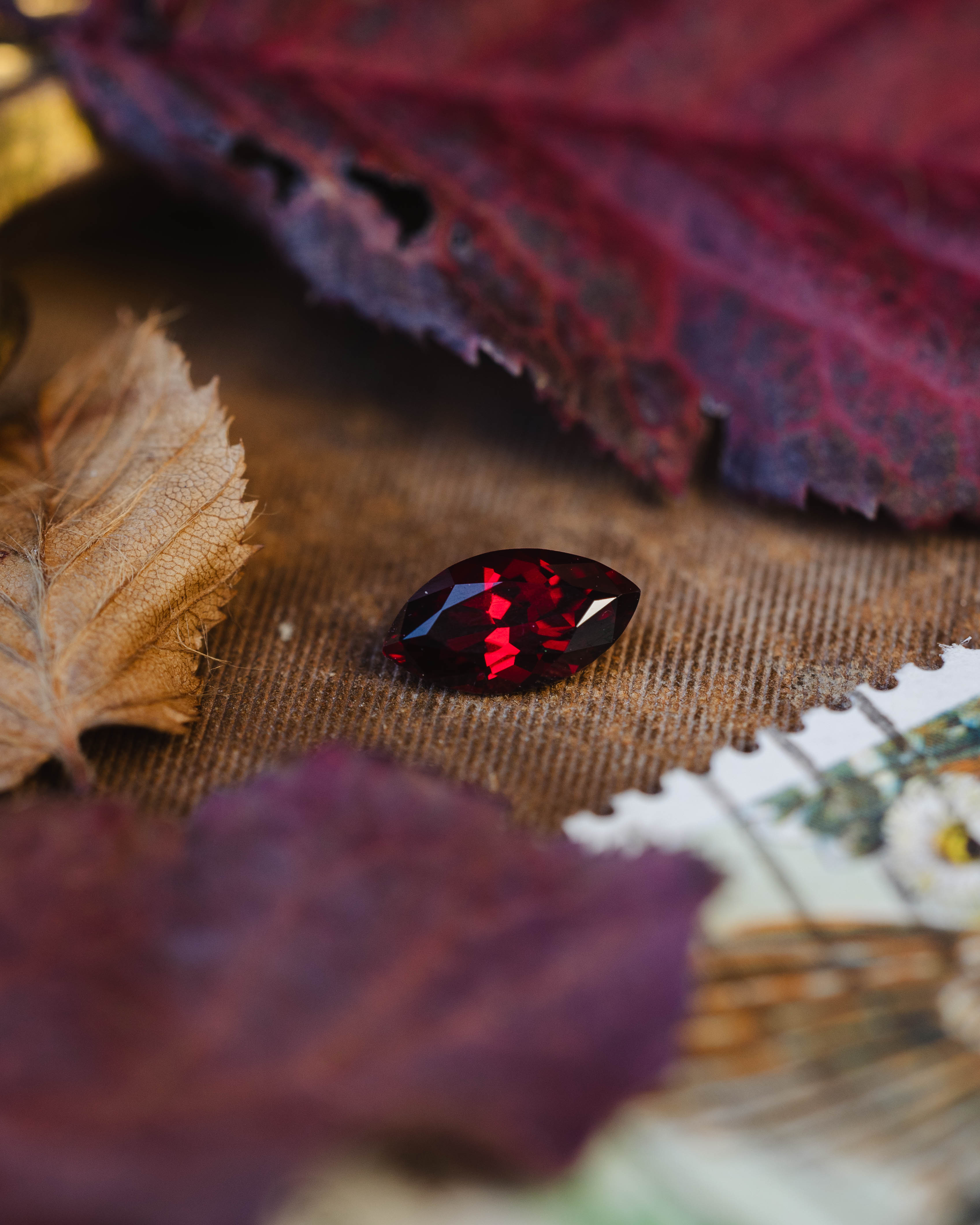 Marquise-shaped red garnet on a textured surface