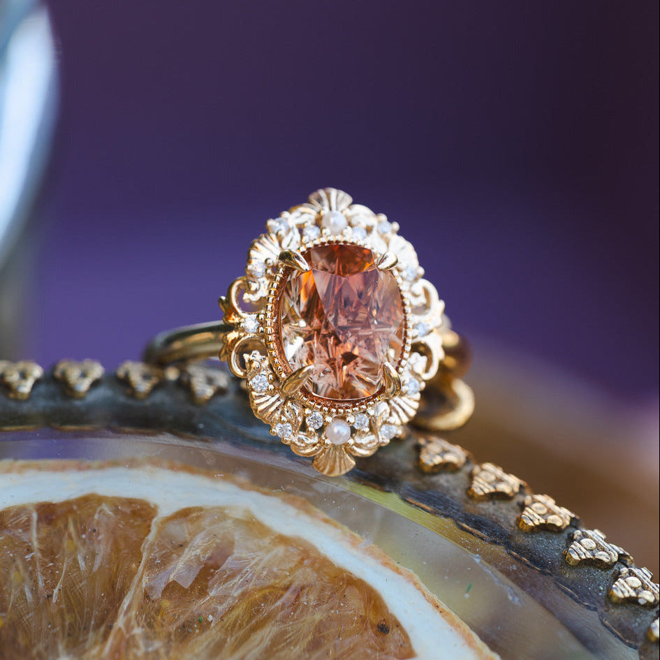 Gold ring with a brown gemstone on a decorative surface