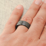 Shown here, a handcrafted men's wedding ring featuring a hammered finish and antler lining.