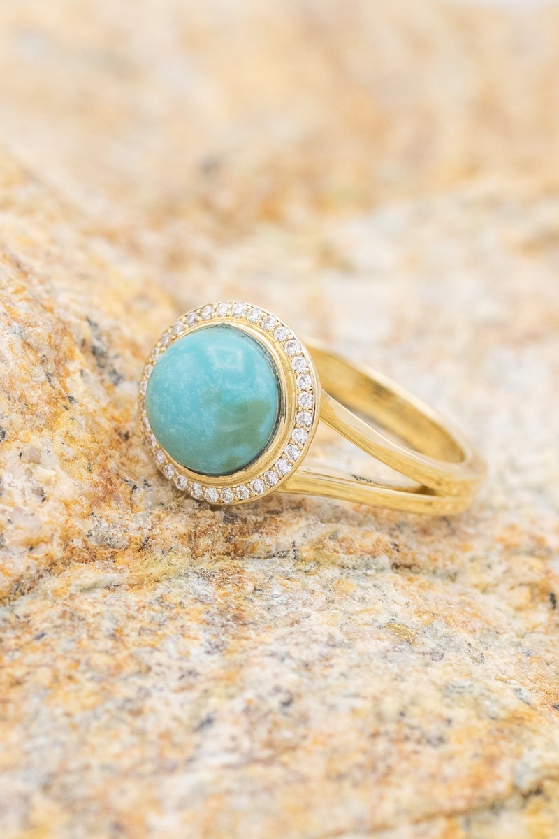 Shown here is The "Terra", a halo-style split shank turquoise women's engagement ring with delicate and ornate details and is available with many center stone options.
