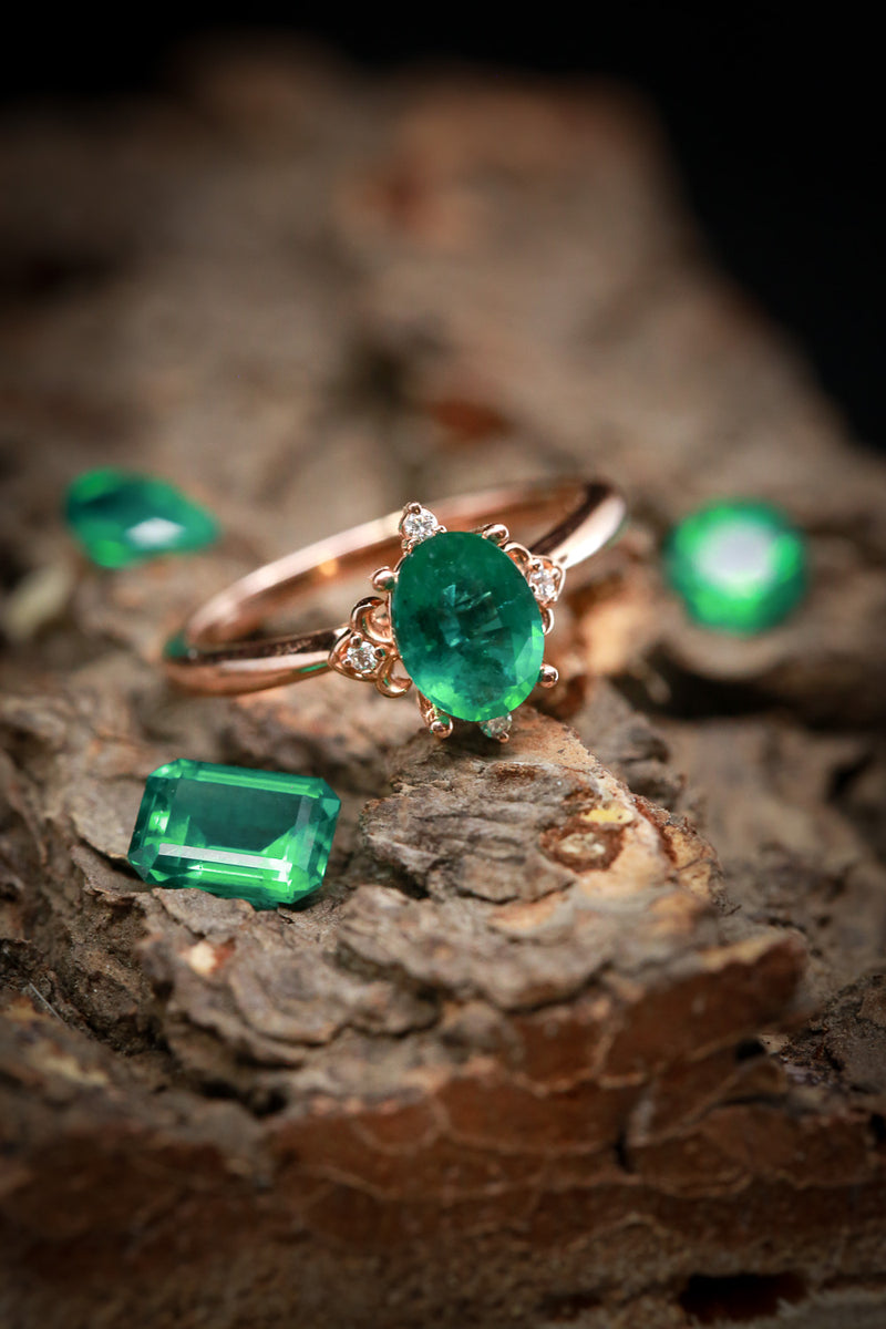 Shown on Wood Among Emerald Jewels is the ZELLA, an Oval Moissante Handcrafted Engagement Ring With Diamond Accents