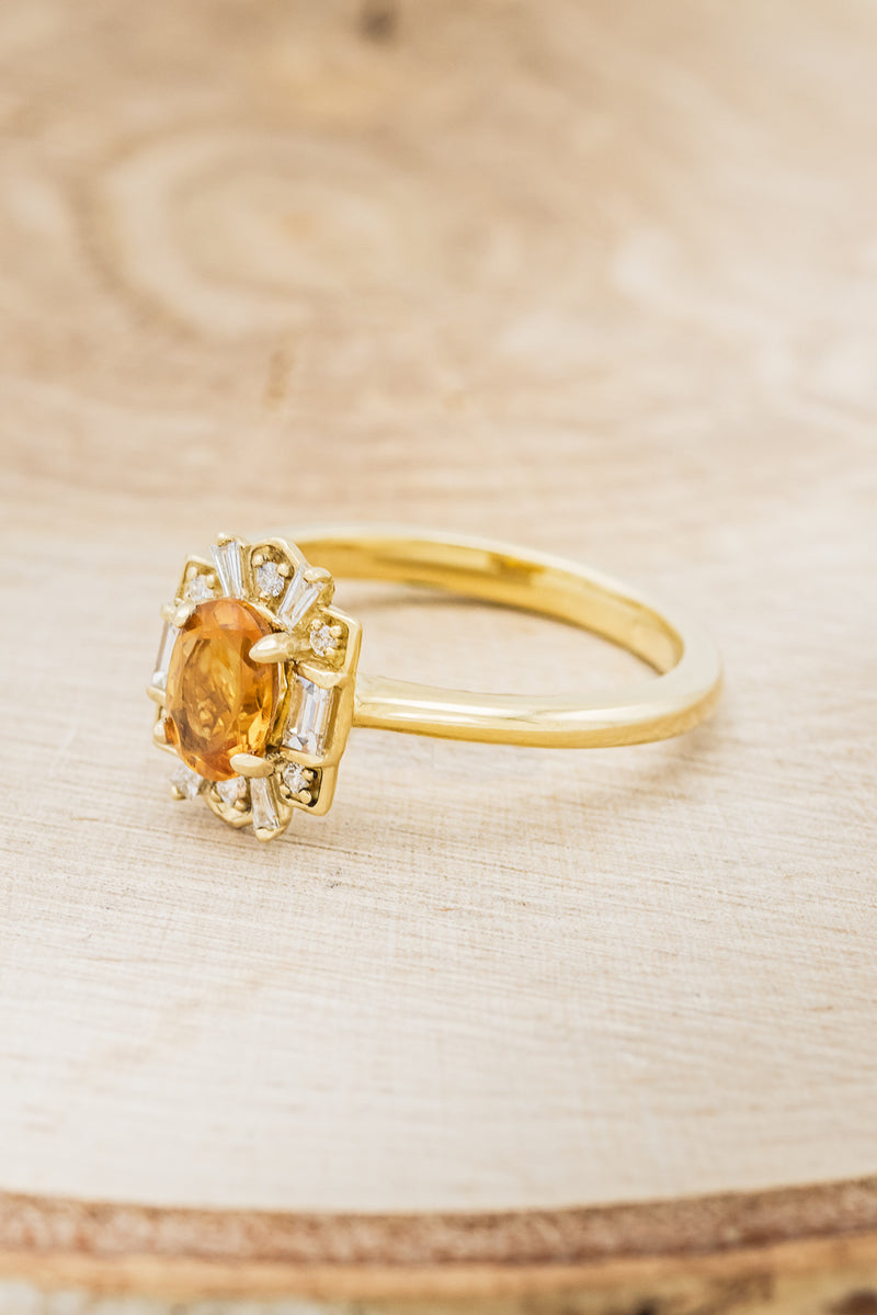 Shown here is"Cleopatra", a women's birthstone ring with a citrine center stone and diamond halo, facing left. Many other center stone options are available upon request.