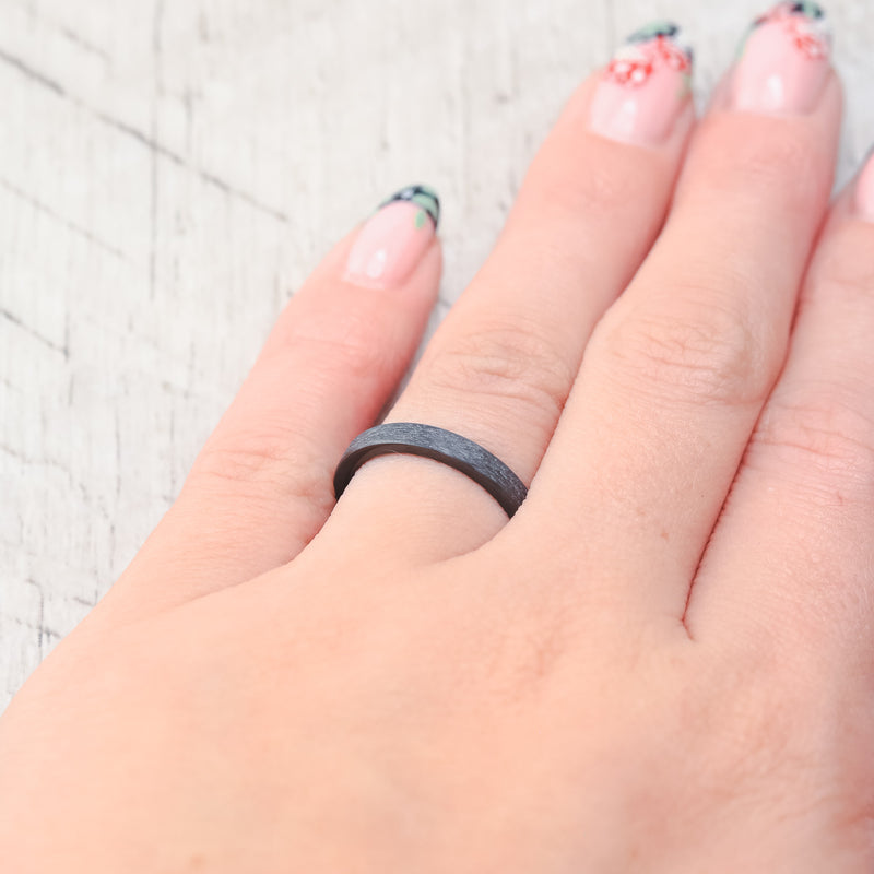Shown here, a matching wedding band set featuring two black zirconium bands with a hammered finish.