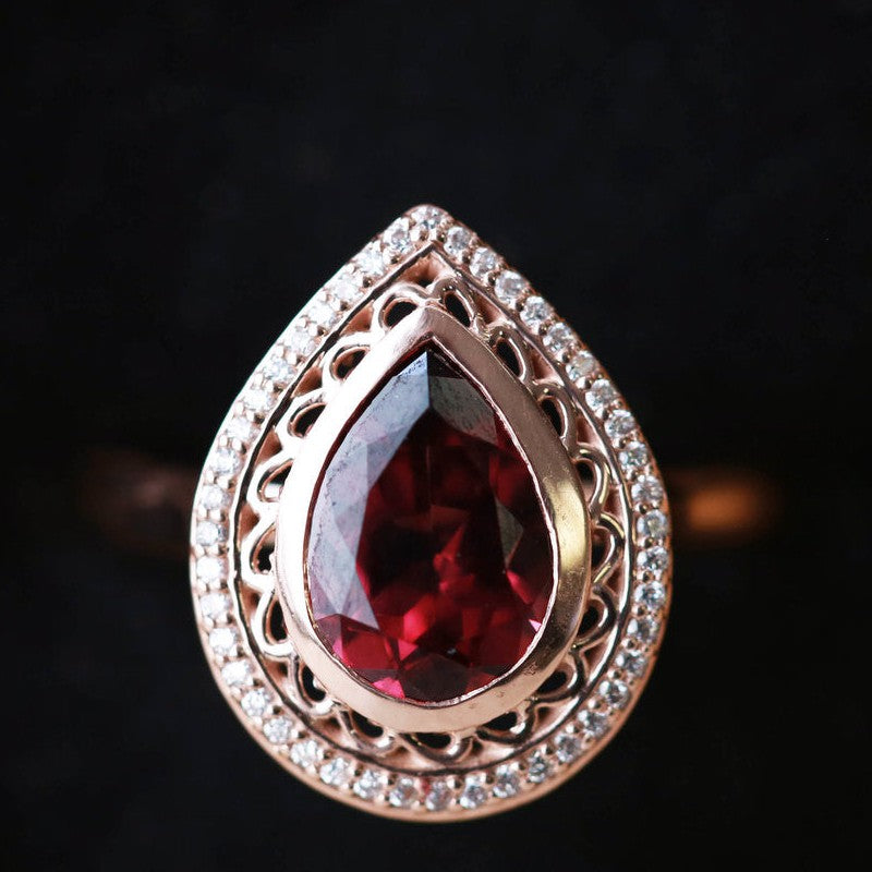 Shown here is a halo-style Garnet women's engagement ring with delicate and ornate details and is available with many center stone options-14K GOLD ENGAGEMENT RING WITH PEAR SHAPED GARNET AND DIAMOND HALO (available in 14K white, yellow, or rose gold) - Staghead Designs - Antler Rings By Staghead Designs