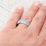 Shown here, a handcrafted men's wedding ring featuring a faceted solid band with a sandblasted finish. Additional inlay options are available upon request.